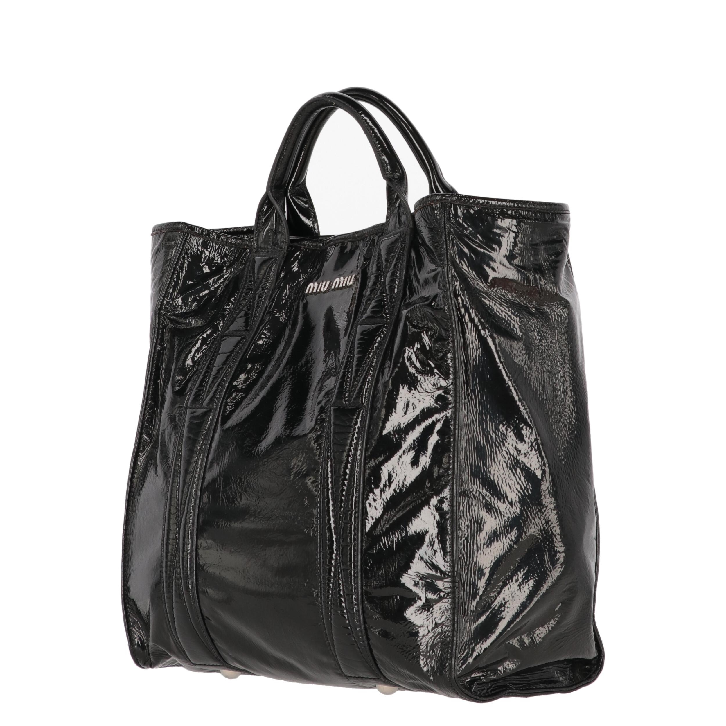Miu Miu black patent leather tote bag. Model with double handles, silver metal details and magnetic button closure.
Years: 2000s

Made in Italy

Flat measurements

Height: 35 cm
Width: 33,5 cm
Depth: 14 cm
Handles height: 30 cm