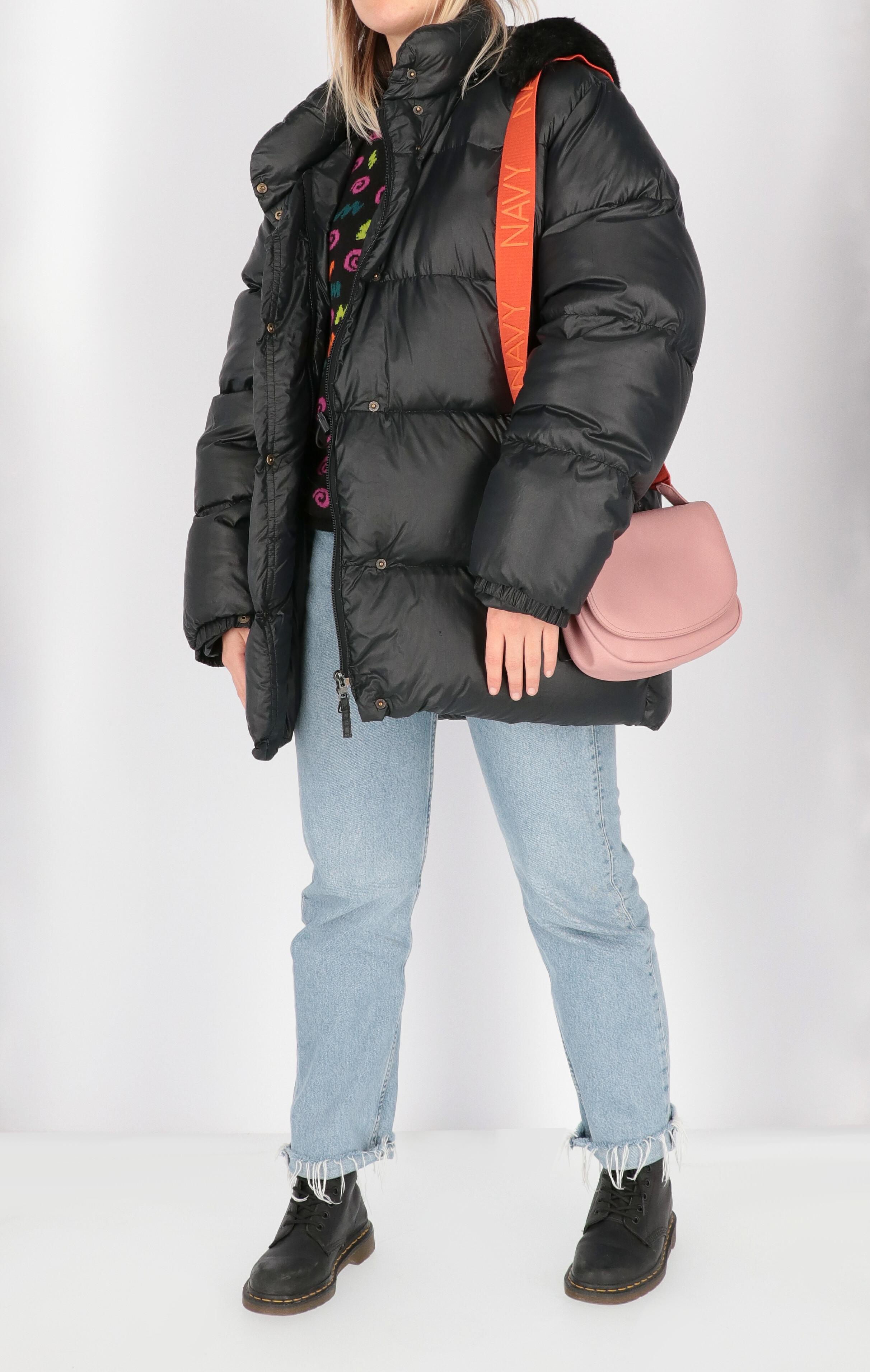 Moncler black down jacket with removable hood and synthetic fur finished edges. Model with stand-up collar, front closure with zip and press buttons and two welt pockets with zip.

The item has some slight signs of wear as shown in the