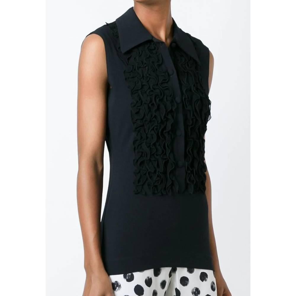 Moschino Cheap and Chic black blouse, classic collar, sleeveless, front closure with black buttons and decorative front ruffles.

Years: 2000s

Made in Italy

Size: 42 IT

Linear measures

Shoulders: 36 cm
Bust: 44 cm