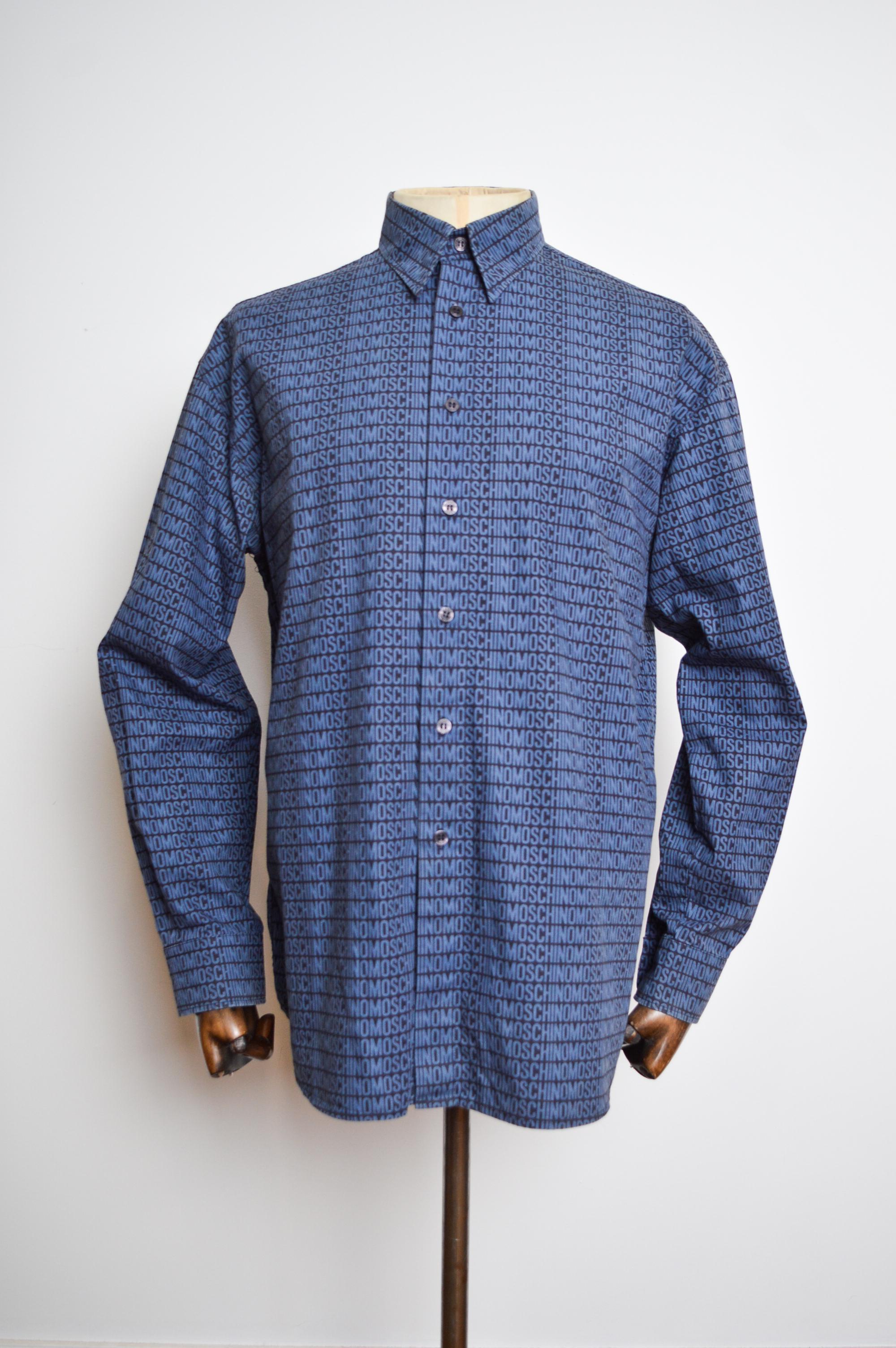 Early 2000's UK Garage Era 'MOSCHINO' repeat pattern Long sleeve Shirt, crafted from a printed cotton in mid Blue & Deep Navy shades.

MADE IN ITALY.   

Features: button down front , Collar, Long sleeves, cuffs, embossed ' Moschino' Buttons.  