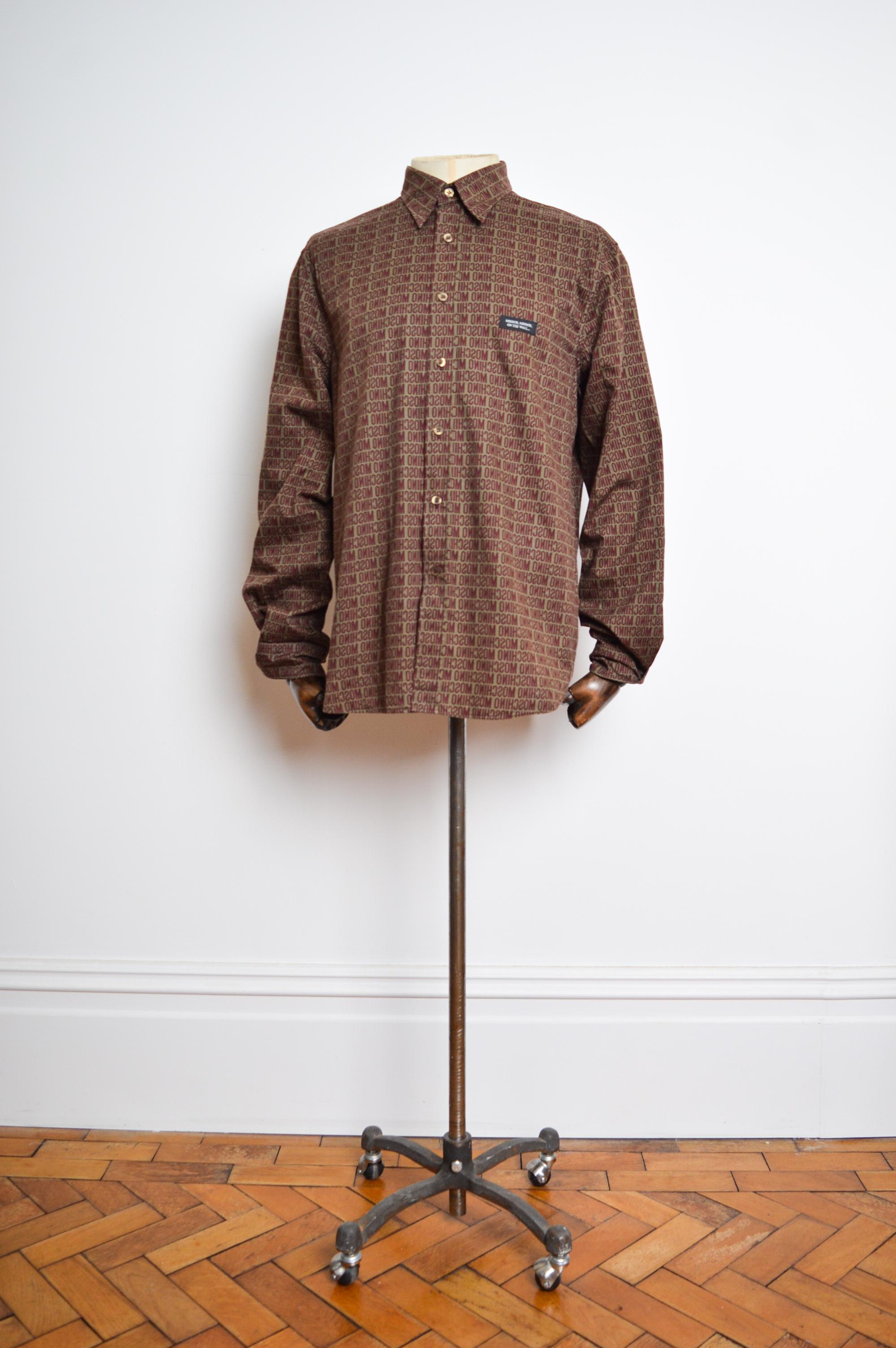 Early 2000's UK Garage Era 'MOSCHINO' repeat pattern Long sleeve Shirt, crafted from a printed cotton in Khaki green & Burgundy shades.

MADE IN ITALY.   

Features: Reverse mirror effect print, button down front , Collar, Long sleeves, cuffs,