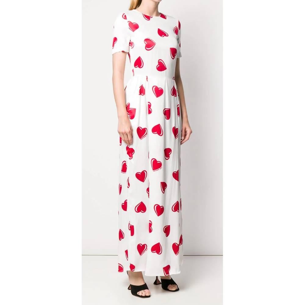 Love Moschino short sleeved long dress in white viscose with red hearts print and logos. Crew-neck model with a fitted waist, soft pleated skirt and back zip fastening.

This item belongs to a deadstock, it has never been worn and comes with its