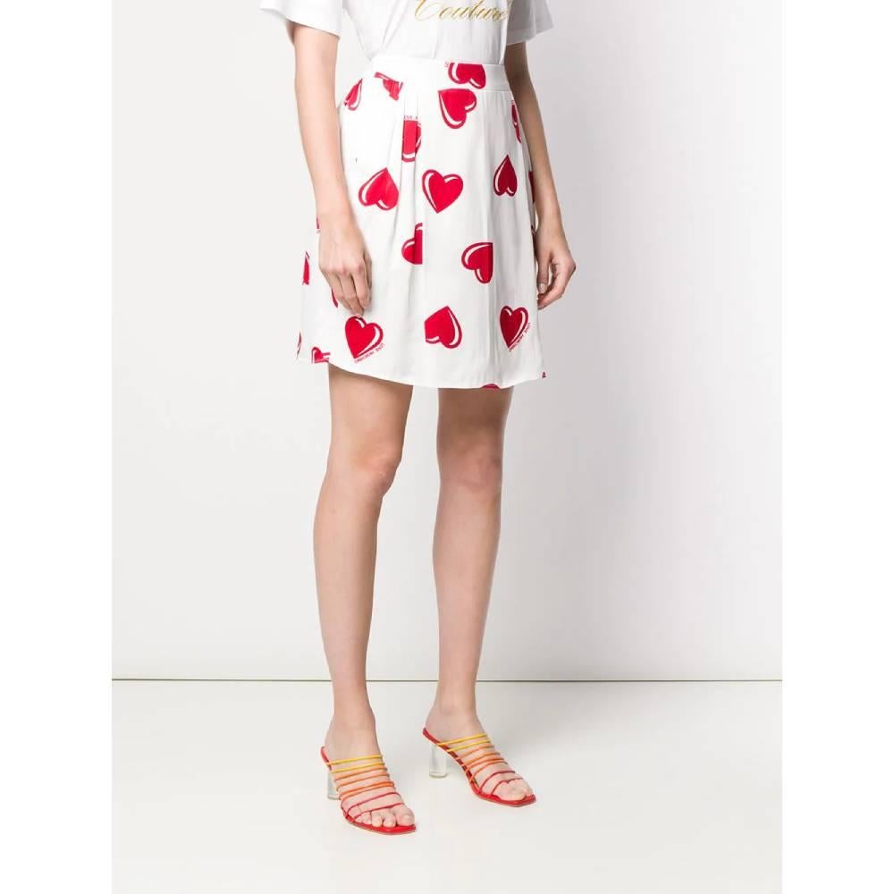 Love Moschino short skirt in white viscose with red hearts print. Model with high waist, belt and pleated design.

This item belongs to a deadstock, it has never been worn and comes with its original tag.
Years: 2000s

Made in Italy

Taglia: 44