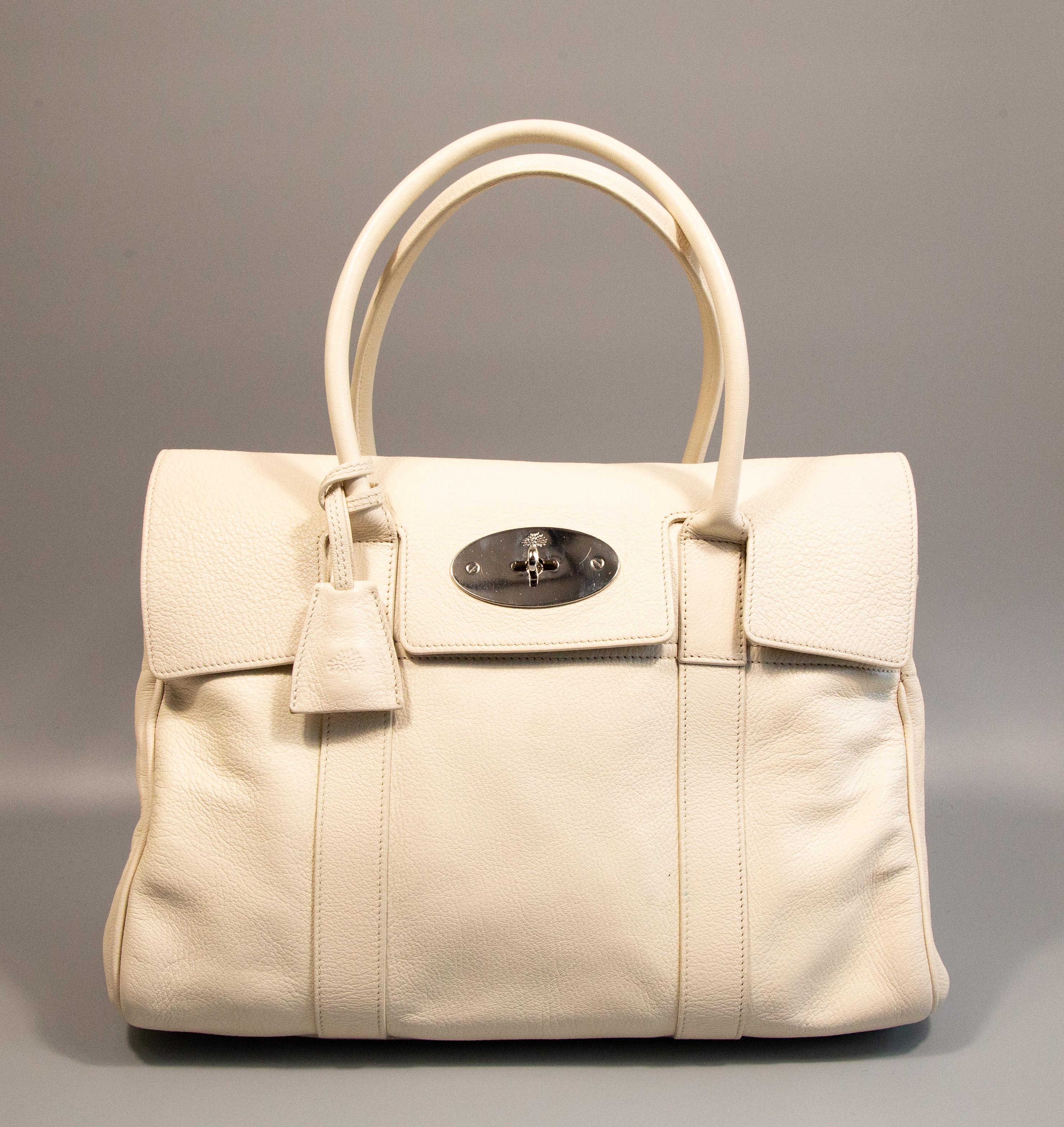 Mulberry Bayswater made of white leather with silver toned hardware. The interior is lined with suede and next to the major compartment it features one side pocket with a zipper. The bag is in very good condition with very minor signs of use such as