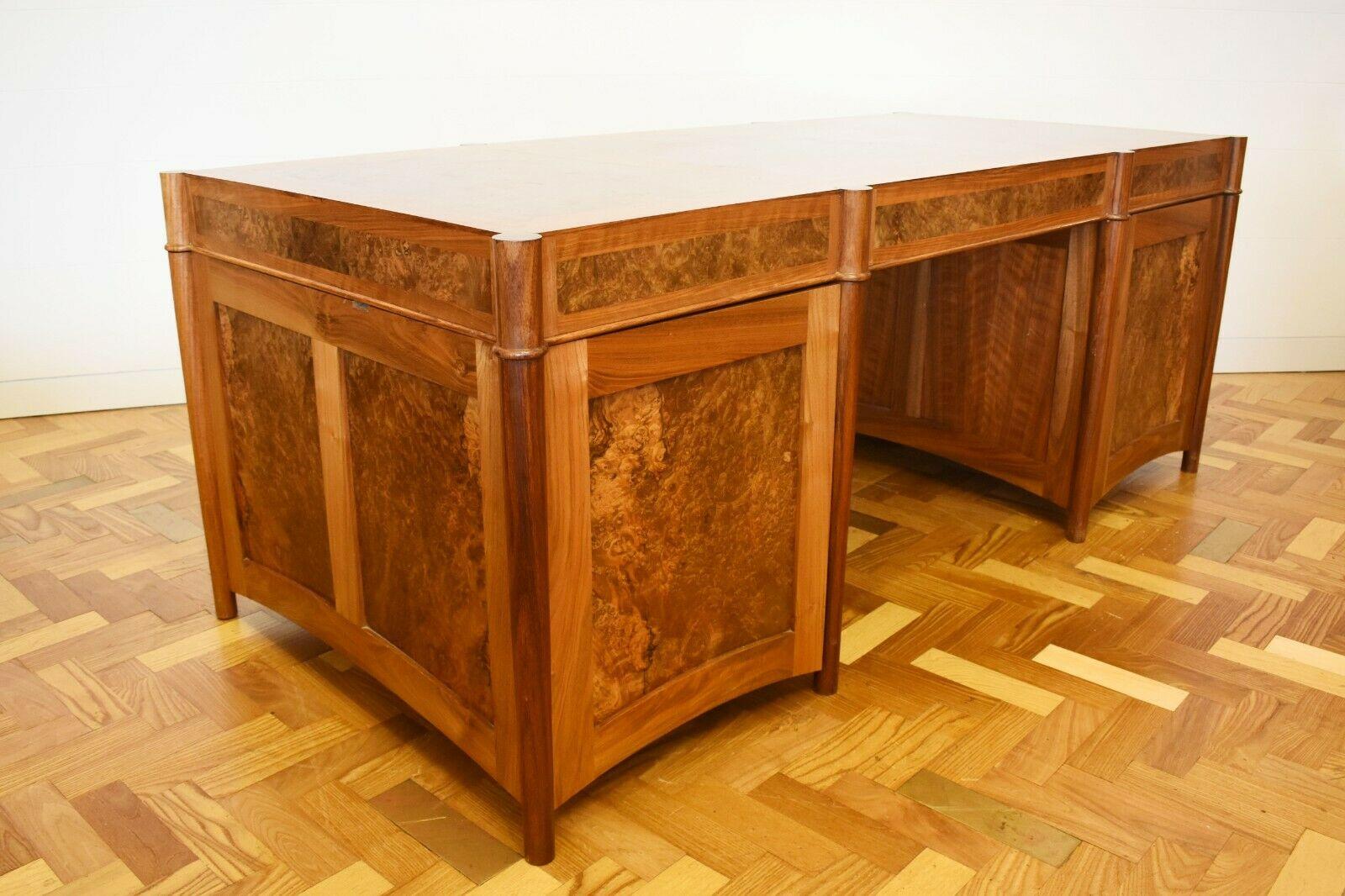 This is a burr walnut bespoke made desk by Nick Karey for The Brake c.2000's

The rectangular top sits above three frieze drawers and two cupboard doors, set upon cylindrical supports. One of these cupboards conceals two drawers, which are perfect