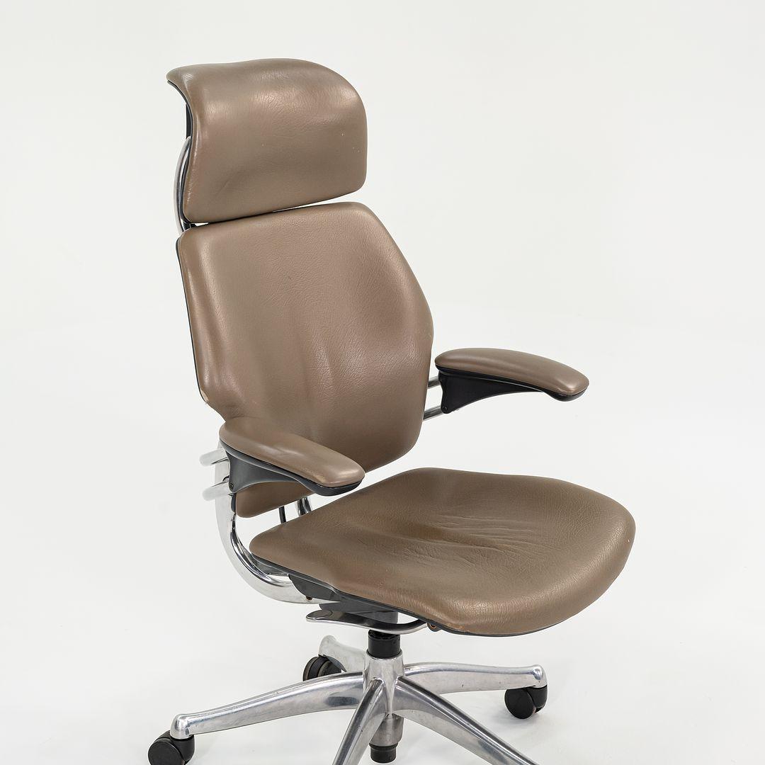 This is a Freedom desk chair, originally designed by Robert King and Niels Diffrient in 1999. This particular example was produced by Humanscale in the USA in the 2000s. The chair features an aluminum 5-star base and is upholstered in a brown