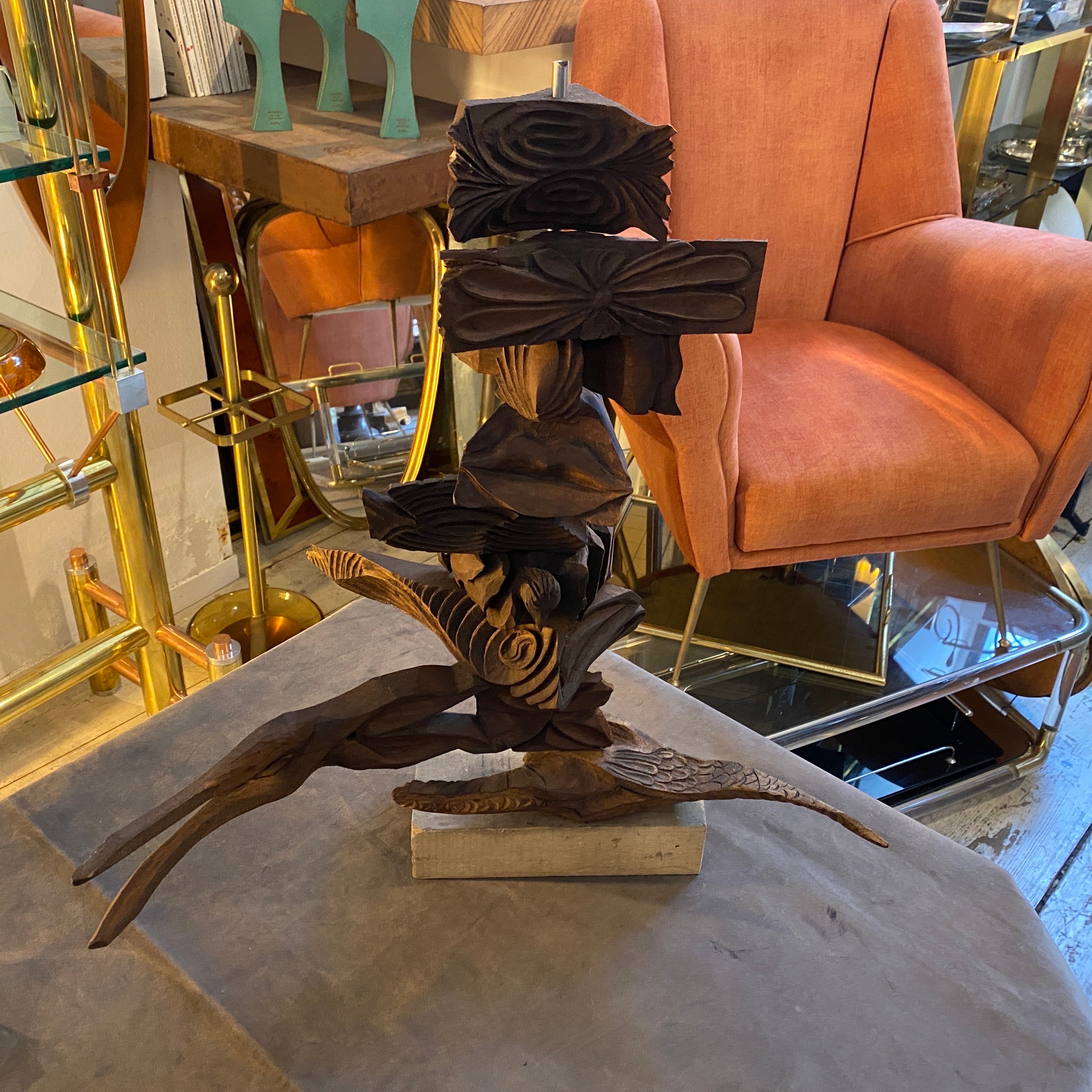 This sculpture is a contemporary, hand-carved wooden artwork from the 2000s. It features a series of intricately shaped wood blocks and organic forms stacked in a vertical arrangement. The unique design includes geometric and natural elements,