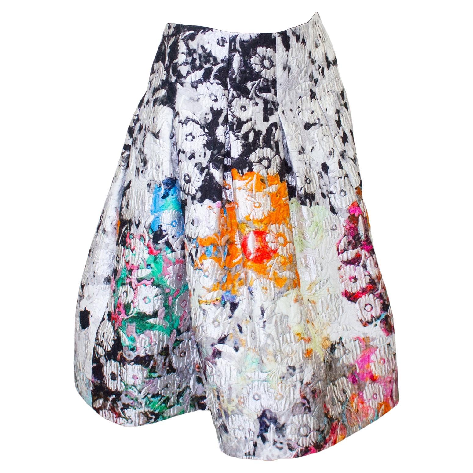 Beautiful Oscar de la Renta early 2000s watercolor flower printed skirt with inverted pleats. The skirt is fitted at the waist and flares out at the hips. The fabric is a nylon, cotton and poly blend and the skirt is fully lined in black silk.