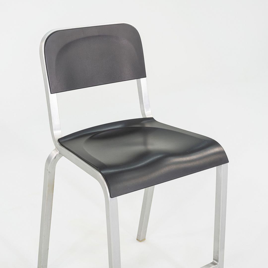 This is a pair of 1951 stools, originally designed by BMW Designworks in 2005. These particular pieces were produced by Emeco in the USA in the 2000s. The stools feature seats and backs in black molded plastic paired with Emeco's signature brushed