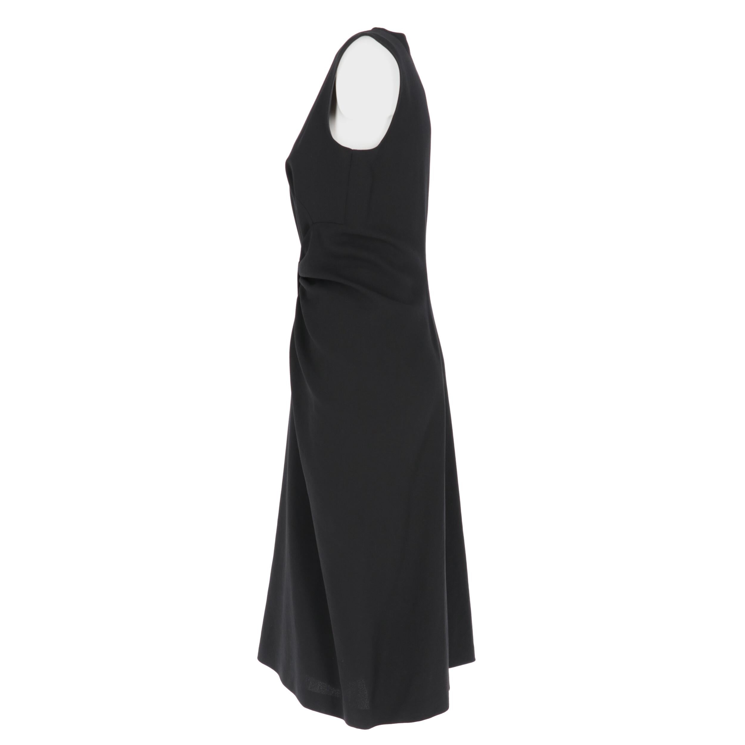 Prada black wool and silk blend crepe dress. Sleeveless crewneck model, with front drape and decorative bow at the waist. Back rear zip fastening and central pleat.
This item comes from a deadstock and has never been worn.

Years: 2000s
Made in