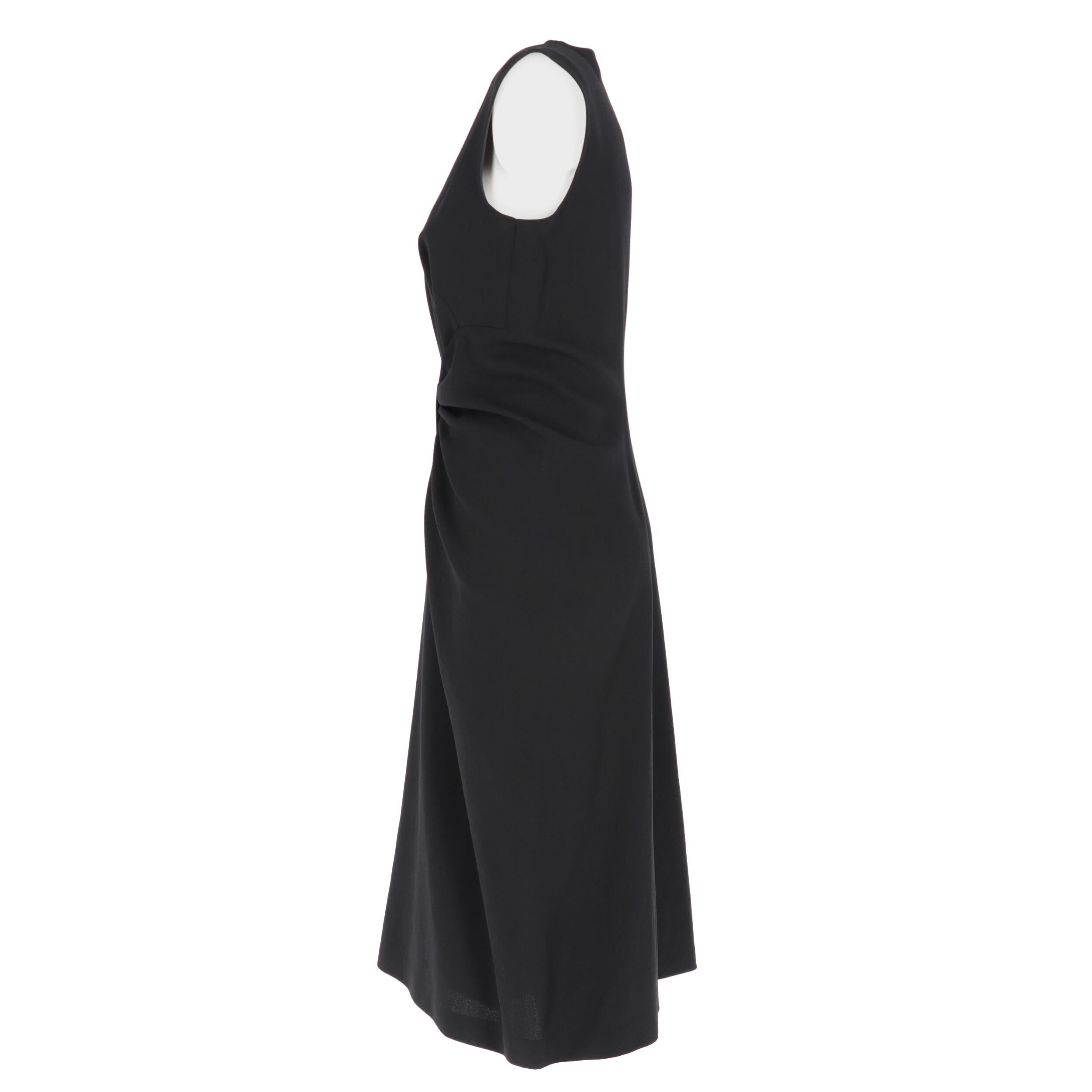 Prada black wool and silk blend crepe dress. Sleeveless crewneck model, with front drape and decorative bow at the waist. Back rear zip fastening and central pleat.

Size: 42 IT 

Flat measurements
Lenght: 113 1cm
Bust: 43 cm 
Waist: 34 cm