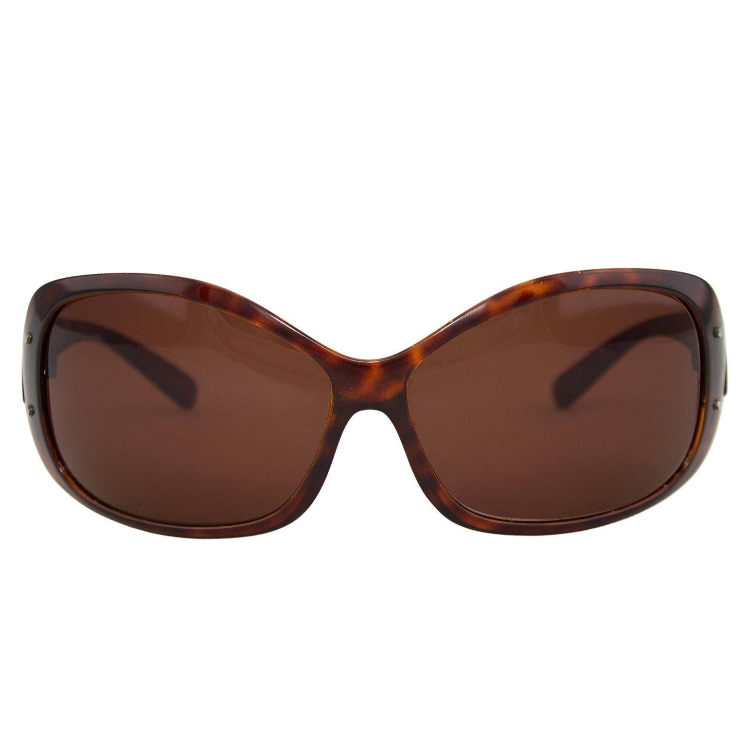 Prada sunglasses from the mid 2000s. Brown tortoiseshell with brown lenses. Slight wrap around style. Prada markings on exterior of arms and interior style information markings. Excellent vintage condition - very light surface wear to lenses, no