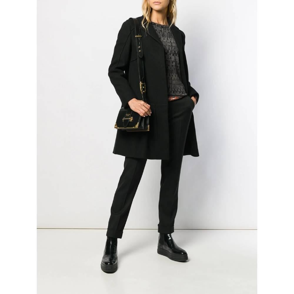 Prada black virgin wool coat. Model with classic collar and front closure with snap buttons. Pleated detail on the bottom and long sleeves. Lined. 

Years: 90s

Made in Italy

Size: 40 IT

Flat measurements

Height: 91 cm 
Bust: 43 cm
Shoulders: 39