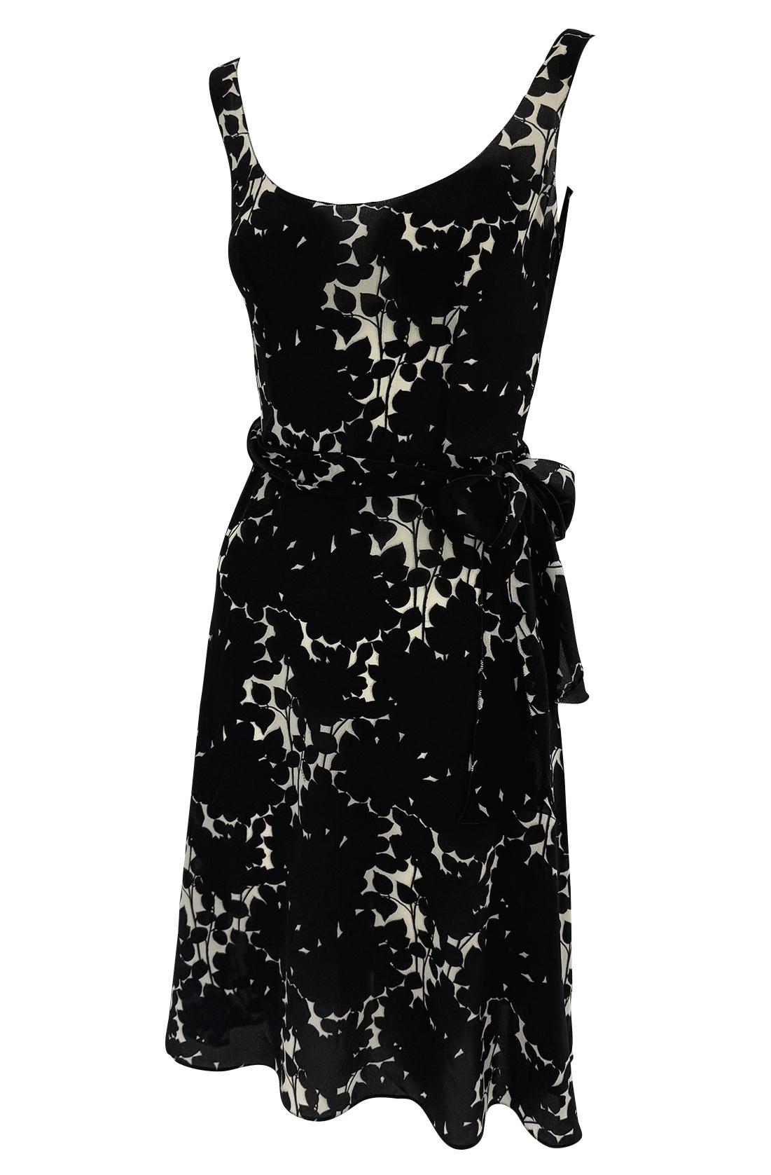 This Prada dress features a sheer silk chiffon fabric with an abstract black and white floral print. Designed with a deep scoop neckline, self-tie waist, and plunging draped back. 

Approximate measurements:
Size - IT40
Bust: 32' - 33