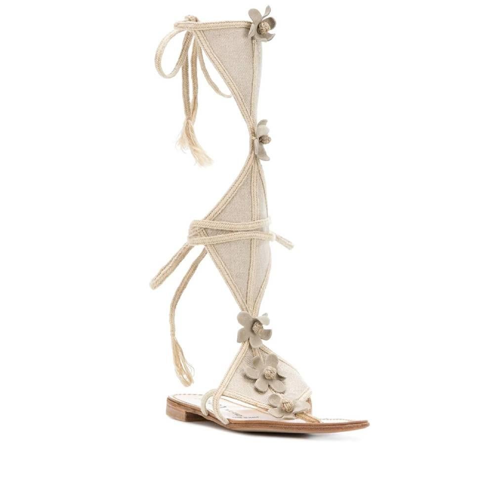 Prada low gladiator sandals in beige canvas with decorative suede flowers and laces on the back. Thong model and logoed sole.

Years: 2000s

Made in Italy

Size: 38,5 EU

Insole: 24.5 cm

