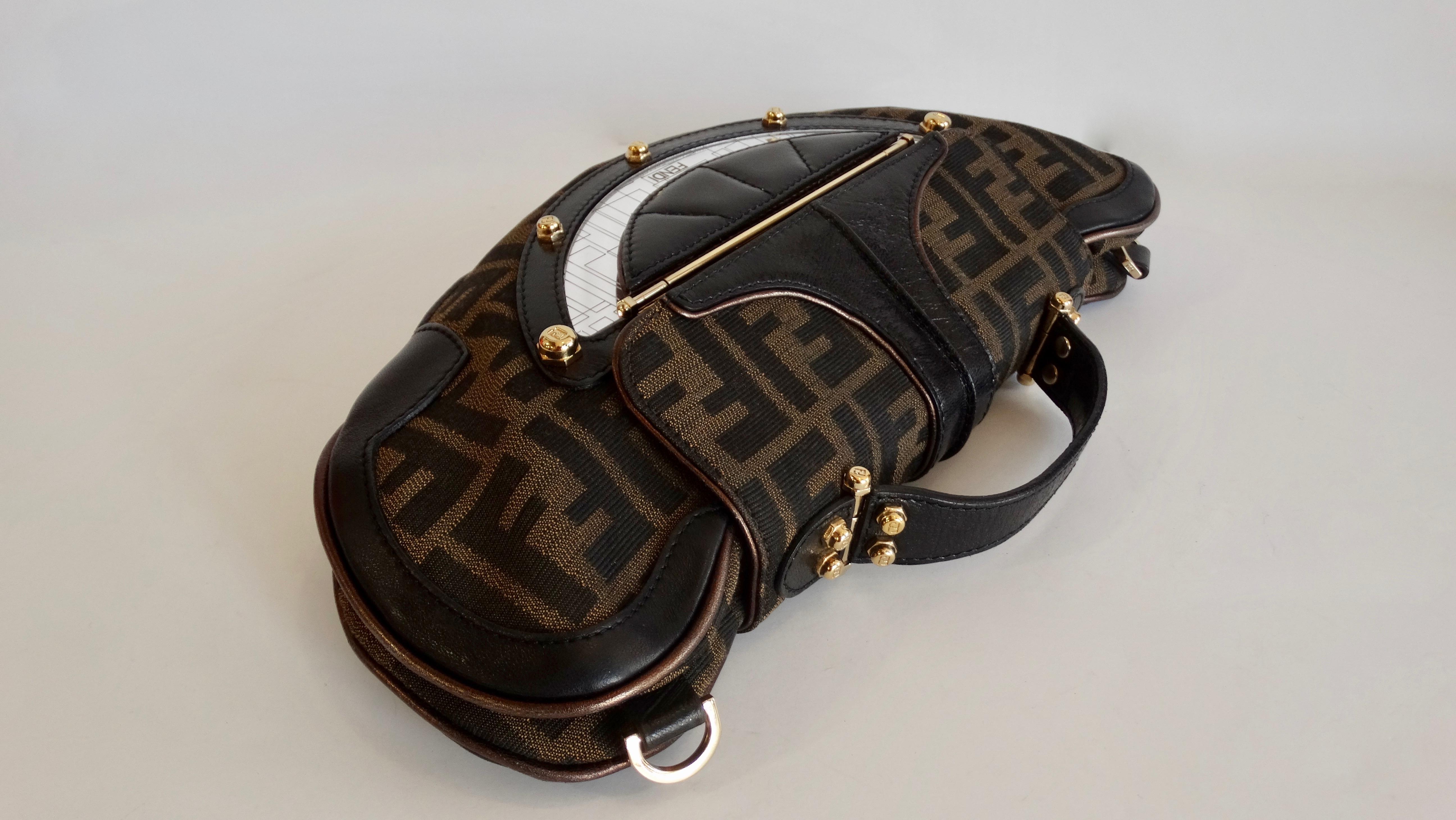 A good Fendi monogram bag is a necessity! Circa 2000s, this rare Fendi canvas purse features their iconic monogram, dark and metallic brown leather detailing, and gold hardware. Includes a monogram exterior lipstick mirror and a removable flat