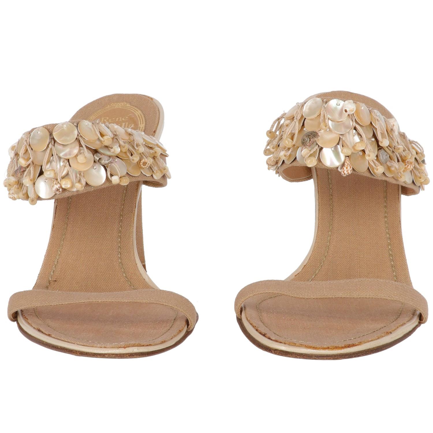 The elegant René Caovilla beige and pearl ivory leather sandals are covered by a soft beige linen. It features a 9 cm spike heels and mother of pearl details and decorative shells. 
The item shows lightly signs of wear and some stains at insole, as