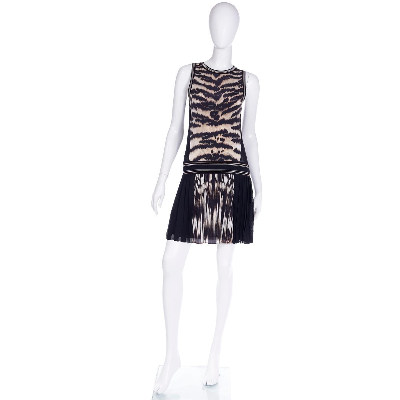 This is a really fun Roberto Cavalli pleated tiger print sleeveless dress. This great drop waist dress has a pleated skirt with lots of movement and a round neckline. The fabric is a tiger print with black and cream and the back is in a sheer black
