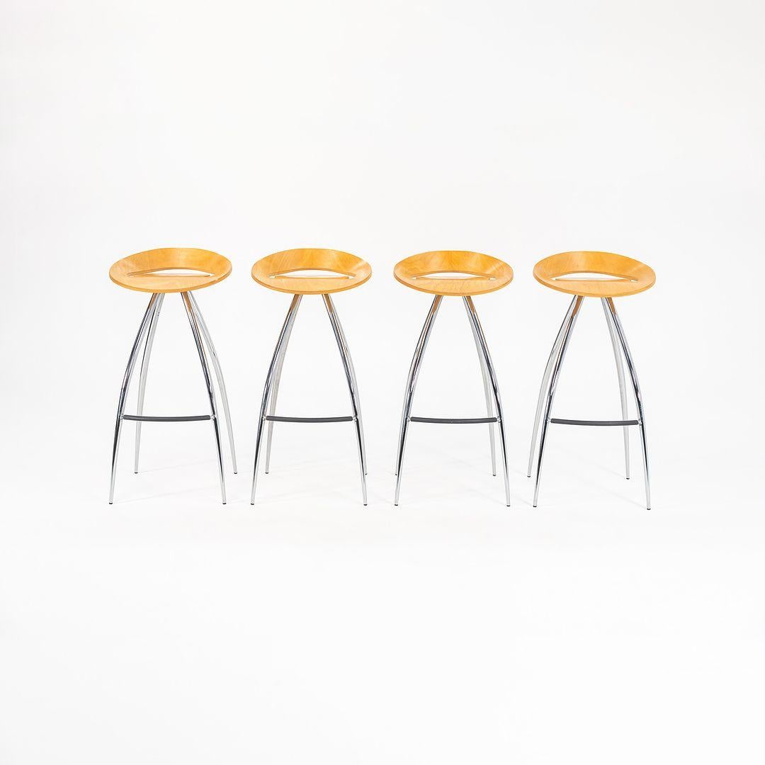 This is a set of four Lyra Bar stools, originally designed by Design Group Italia in 1994. These particular examples were produced by Magis in Italy in the 2000s. The stools are comprised of a chromed steel tube frame and natural beech plywood seat.