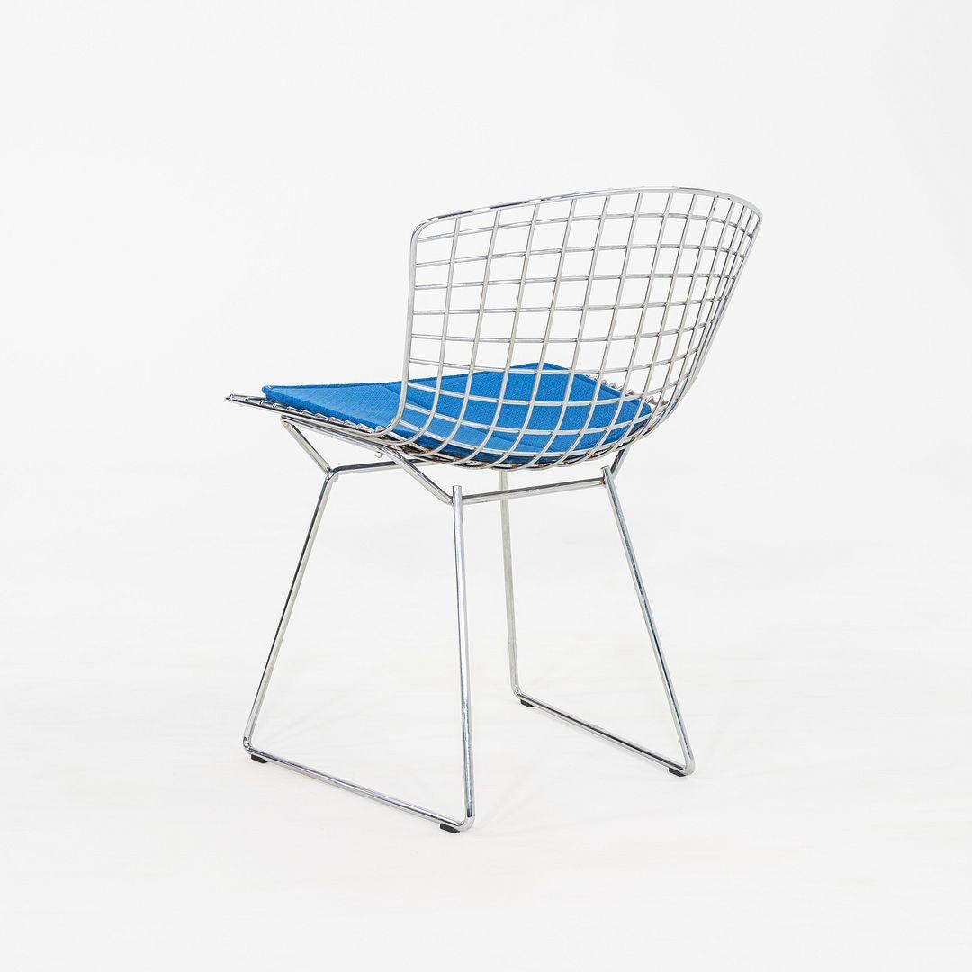 This is a set of five Bertoia Side Chairs, Model 420C, originally designed in 1952 by Harry Bertoia for Knoll International. These particular examples were produced in the 2000s. Their design consists of a welded chromed-steel wire seat & back, and