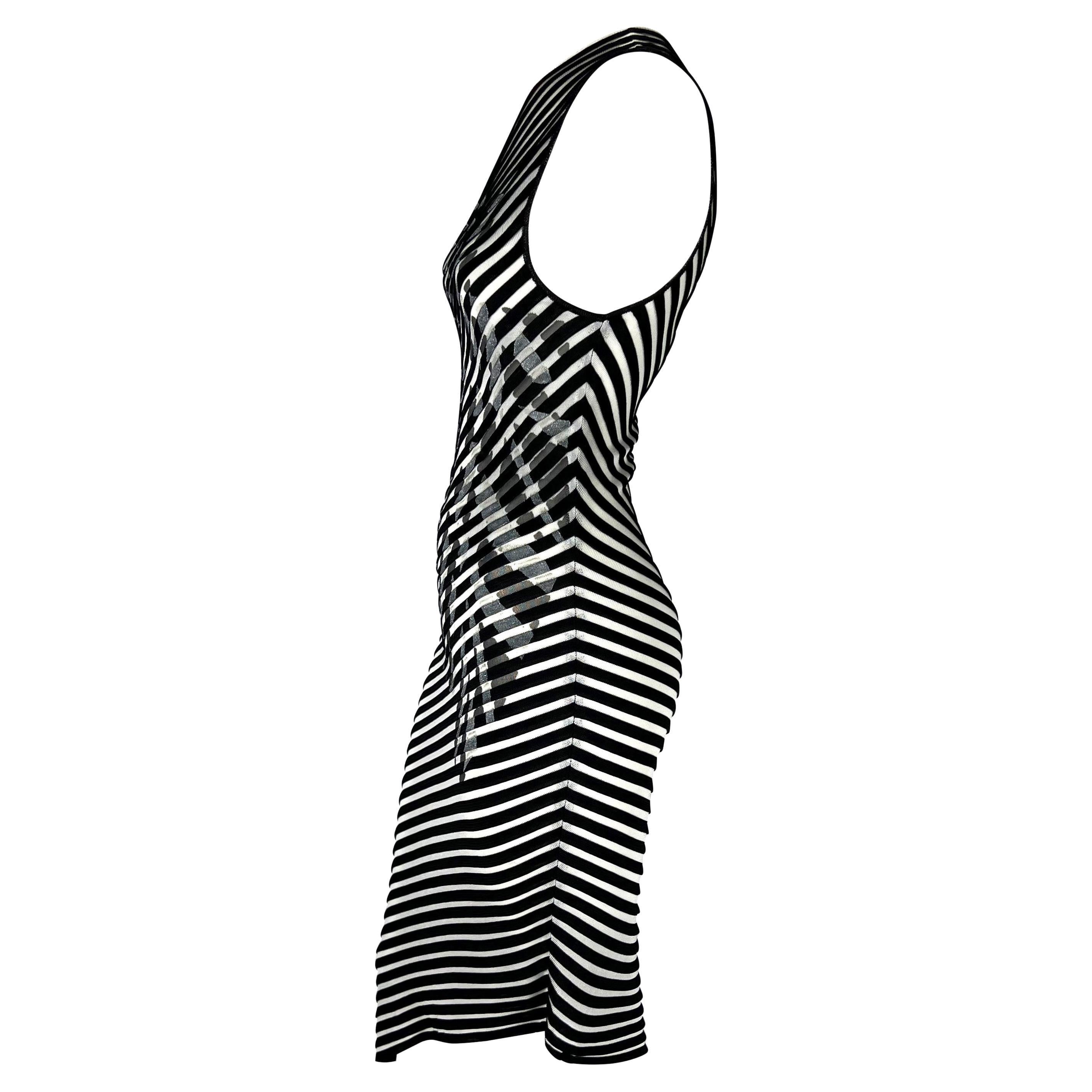 Presenting a fabulous black and white sheer striped Thierry Mugler knit dress. From the early 2000s, this fabulous dress features asymmetrical stripes as well as an asymmetrical neckline and hem. The dress is made complete with a silver metallic