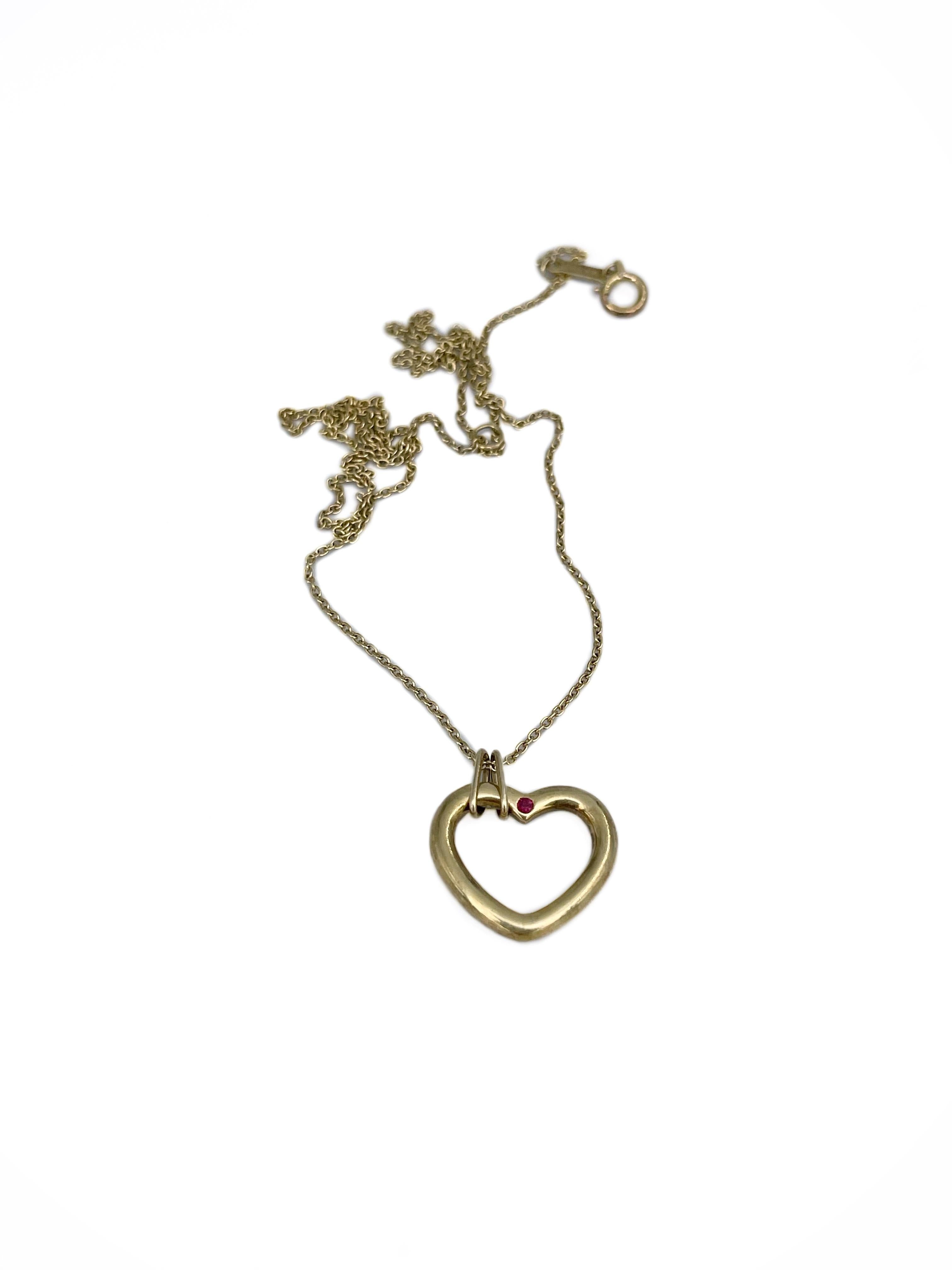This is a classic design heart shape pendant with a chain designed by Tiffany & Co. in 2000s. It is crafted in 18K yellow gold. 

It features 1 ruby: round cut, 0.01ct, R 5/4, VS.

Signed: Tiffany & Co. K18

Weight: 3.92g
Pendant size: