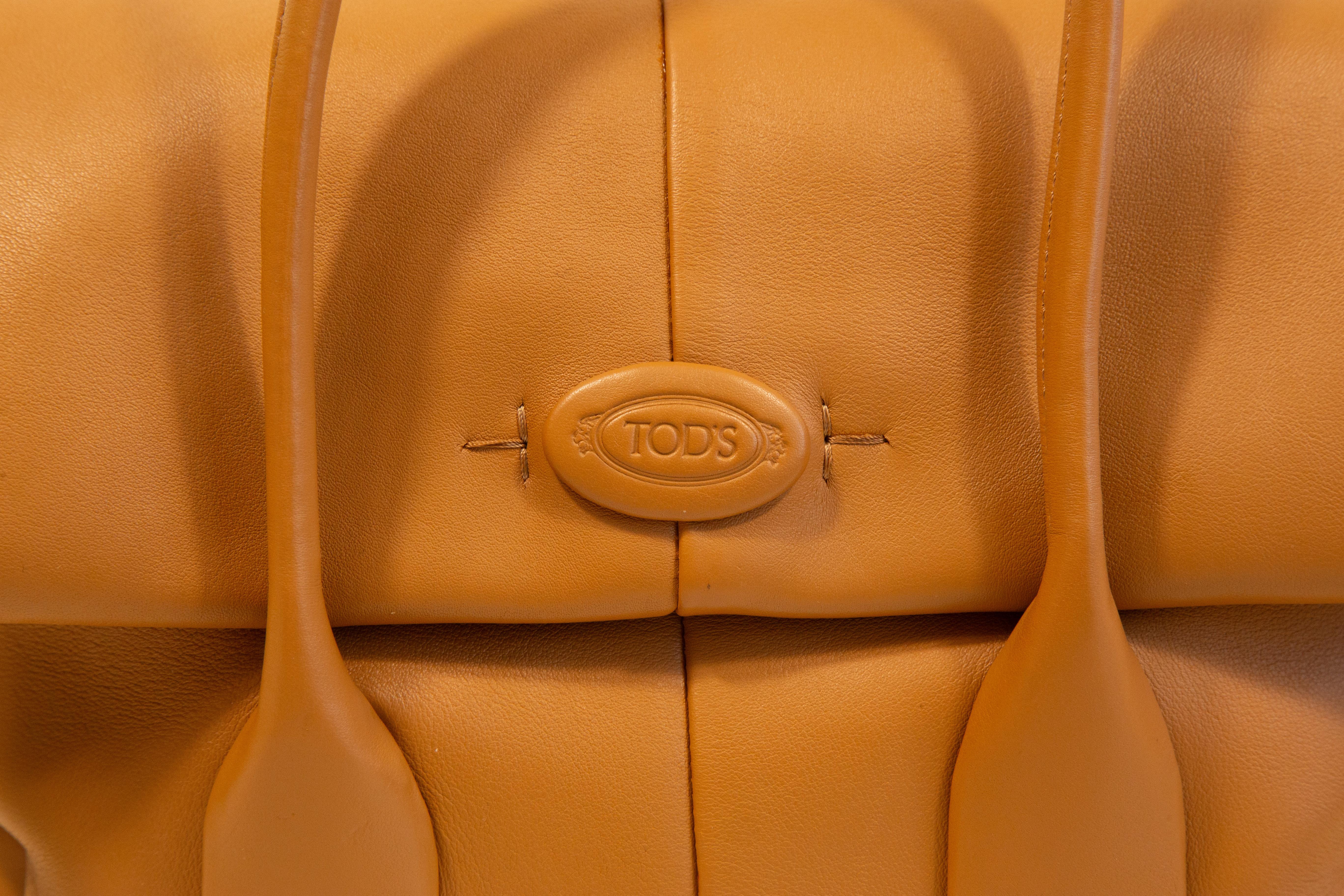 Tod's Di Reverse flap leather shoulder bag/top handle bag. The bag is made of caramel/light brown calf leather with silver toned hardware. It features two rolled top handles and detachable and adjustable shoulder strap (max ca 100 cm). The interior