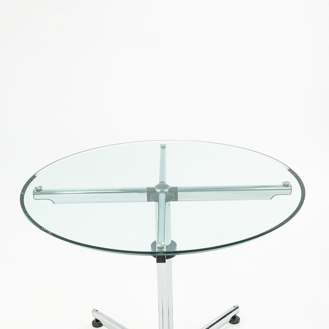 Il s'agit de la table ronde Kitos, conçue par le fabricant suisse USM Haller en 1990. Cette pièce date du début ou du milieu des années 2000. La conception comprend une base en colonnes d'acier et des tubes de soutien en acier sous la partie