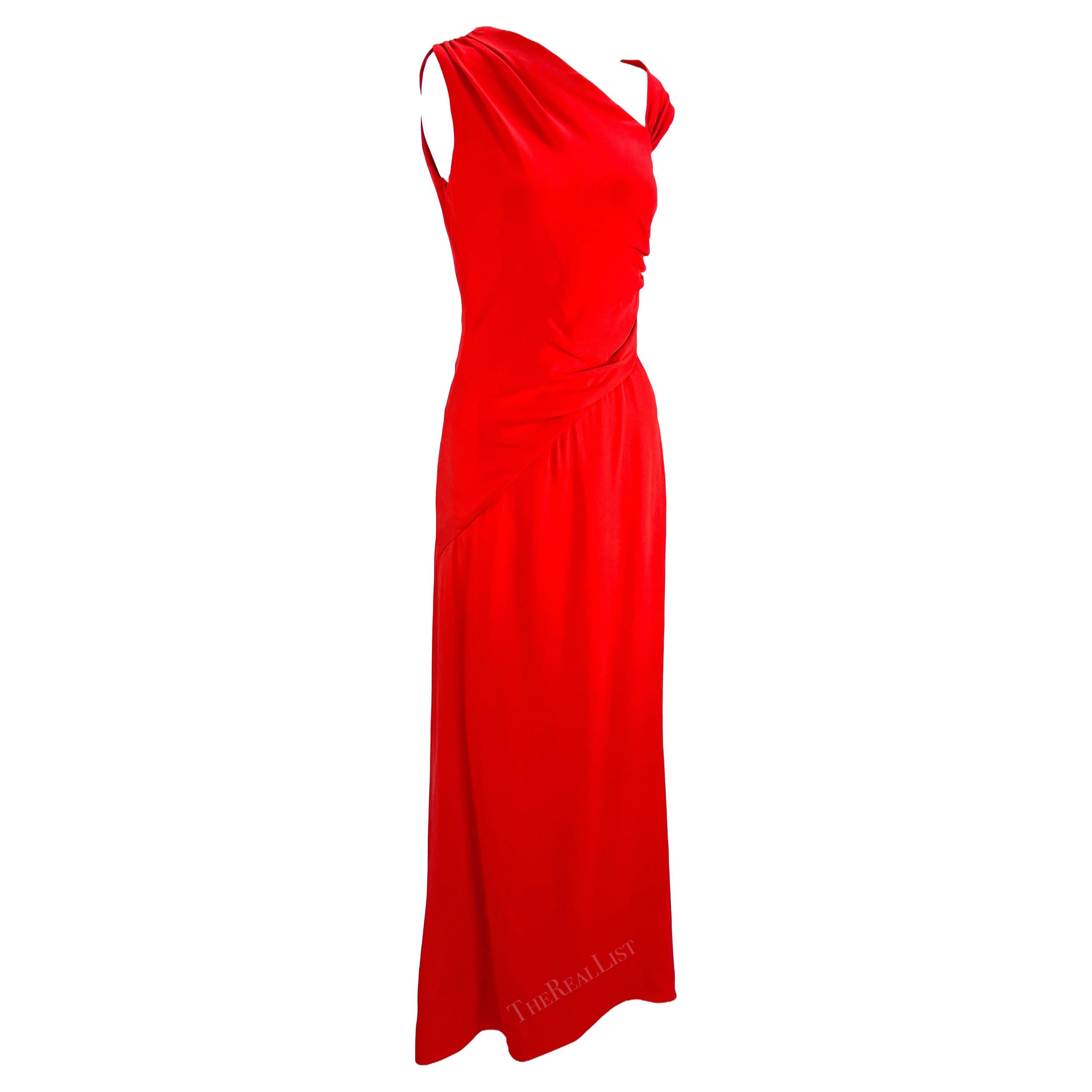 Presenting a gorgeous Valentino gown designed by Valentino Garavani before his retirement in his signature Valentino Red color. From the 2000s, this ankle-length gown features an asymmetric v-neckline and a single off-the-shoulder strap. The dress