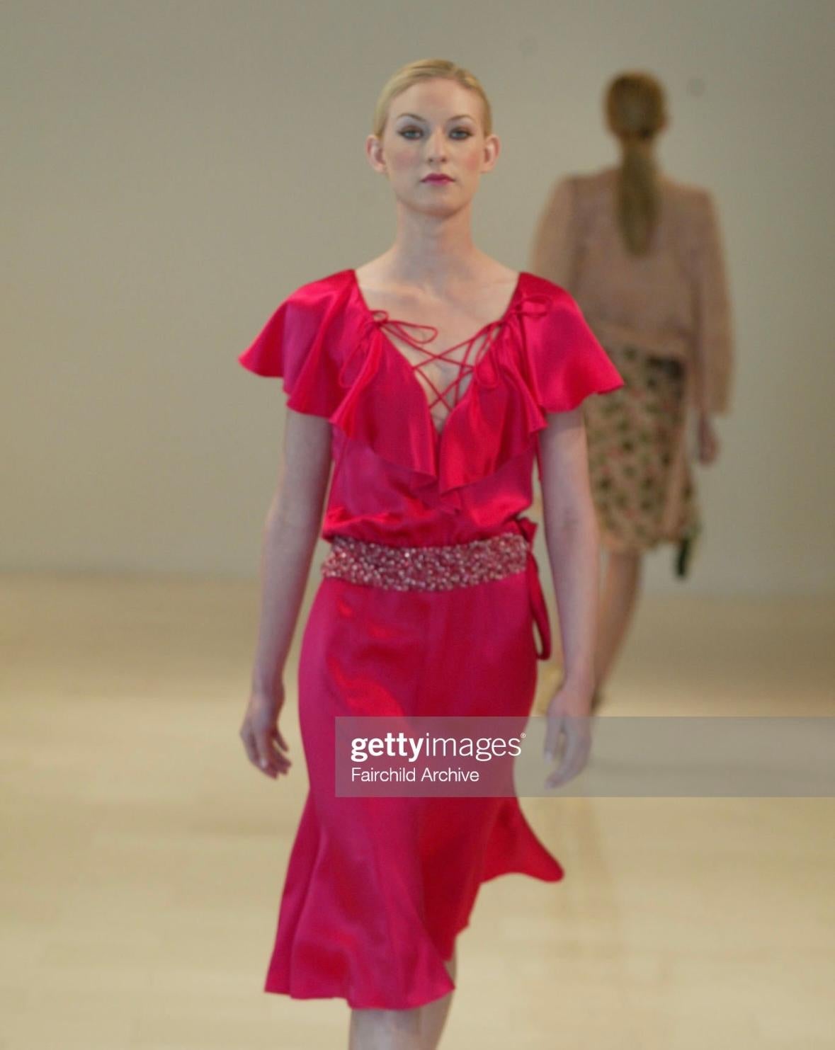 Collectional présente une magnifique robe à volants en satin de soie rose, conçue par Valentino Garavani pour sa collection Resort 2004. Cette fabuleuse robe est entièrement construite en satin de soie et présente des manches pétales à volants, un