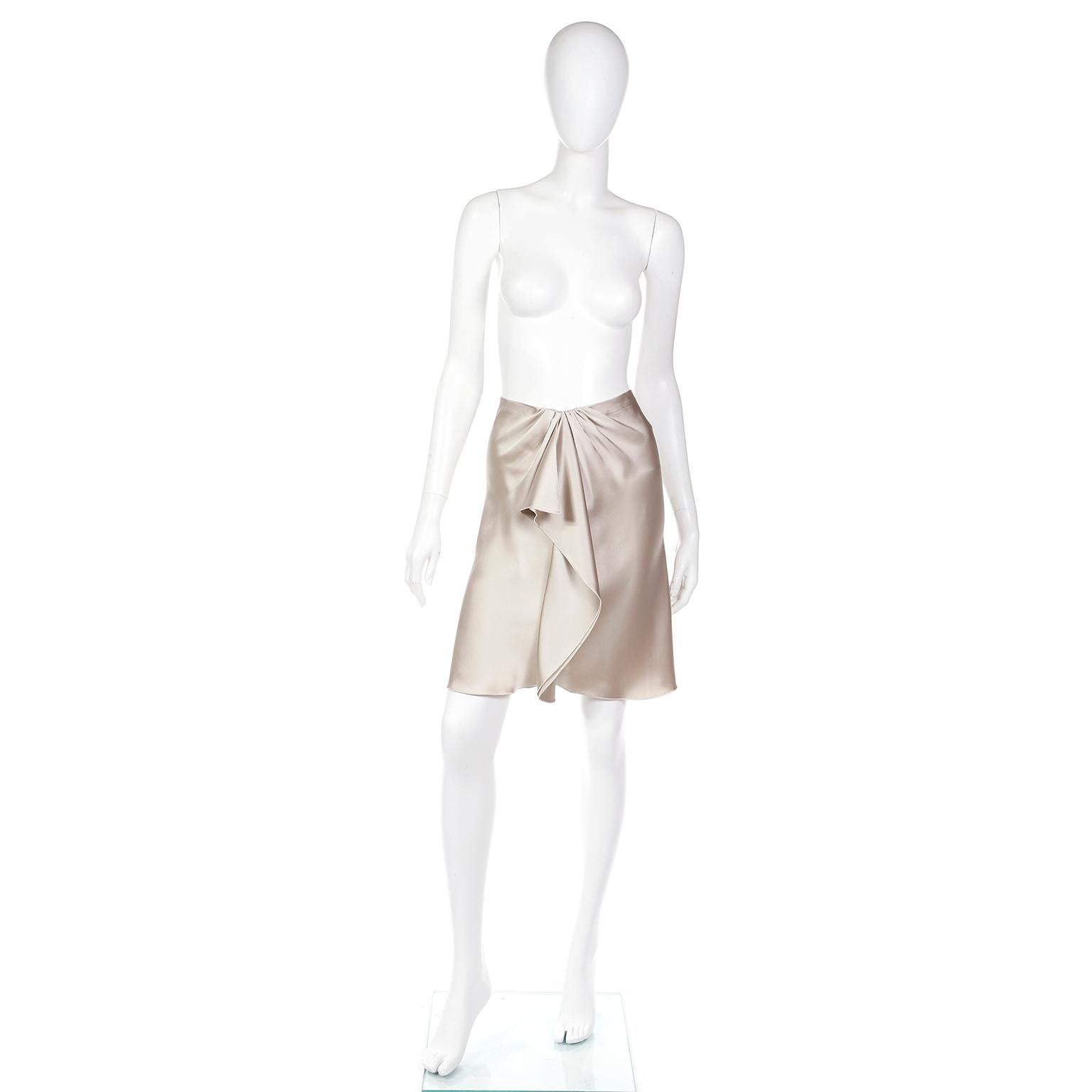 This is a stunning silk Valentino skirt from the 2000s with a lovely gathered and draped silk in front. It is a light taupe silk, and the gathering creates a lovely V at the waistline. This beautiful skirt hits just above the knee, and closes with a