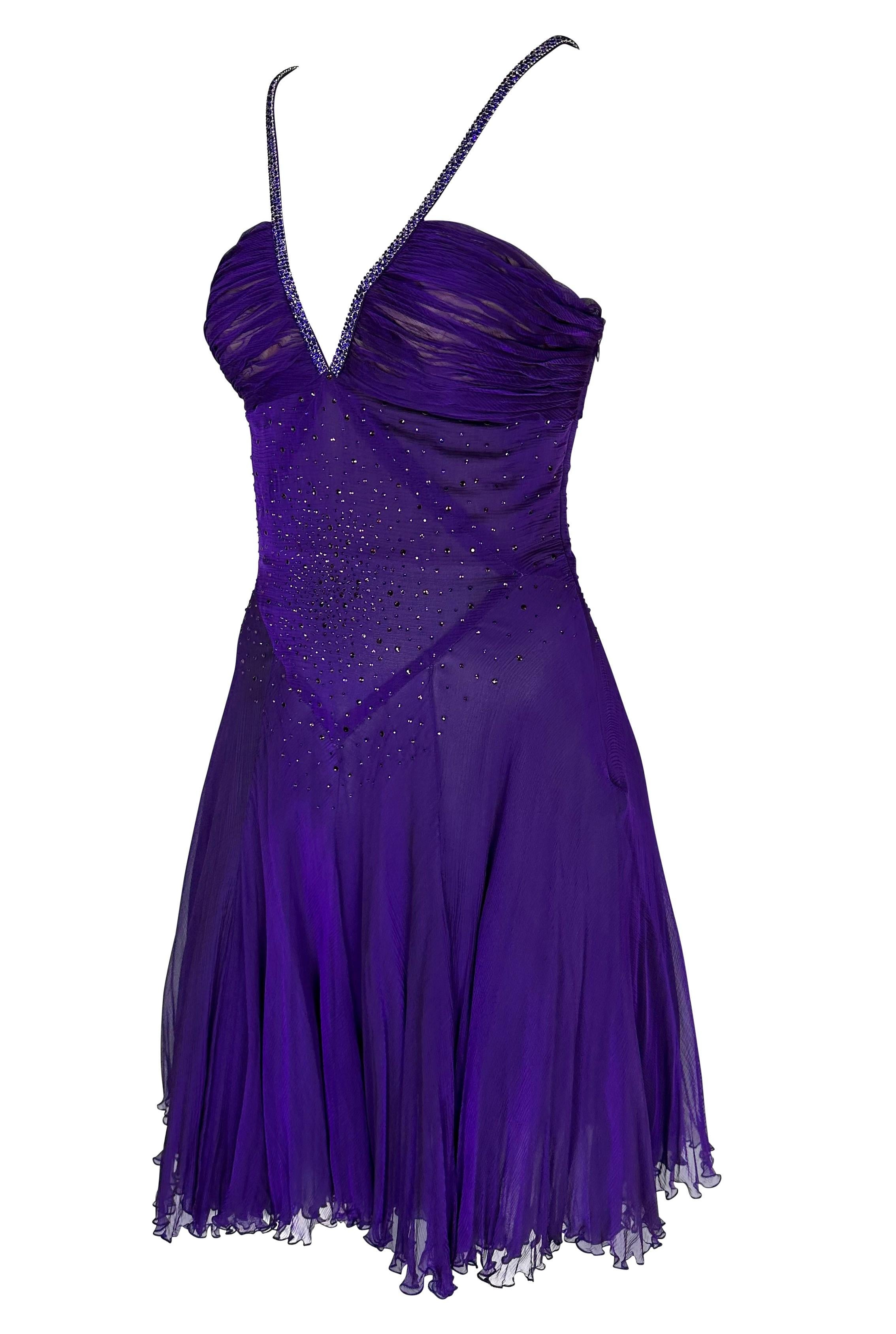 Presenting a beautiful deep iridescent purple Versace dress, designed by Donatella Versace. From the late 2000s, this semi-sheer dress features a deep v-neckline, flared skirt, semi-exposed back, and crystal-covered straps. This fabulous dress is