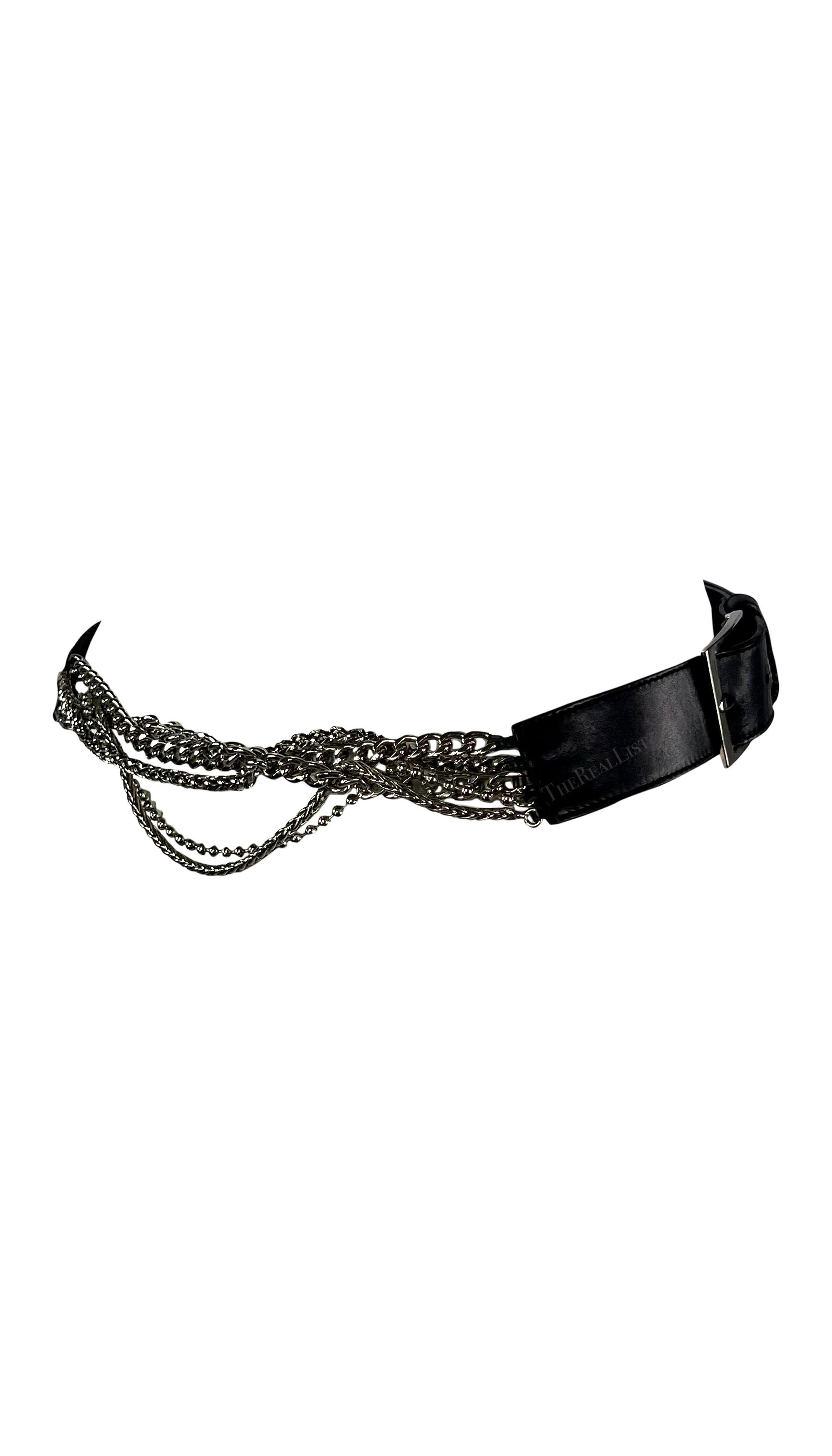 Cette fabuleuse ceinture Versace à chaîne en cuir noir a été conçue par Donatella Versace. Datant du début des années 2000, cette ceinture est composée de cuir et de chaînes en métal chromé. La ceinture comporte deux boucles carrées et est complétée