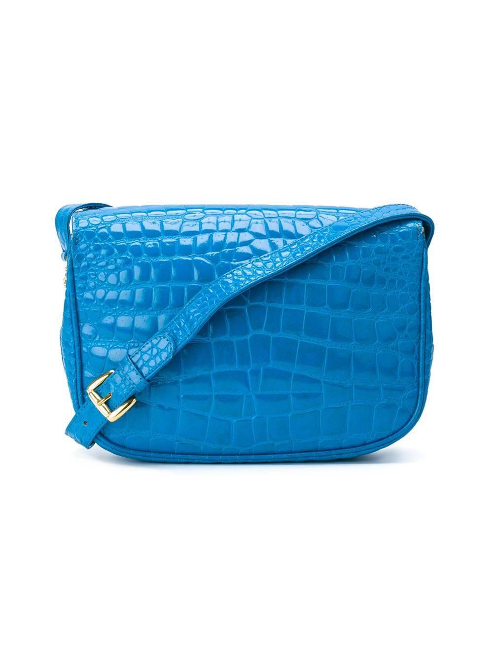 Blue and gold-tone crocodile leather flap shoulder bag from Gianni Versace featuring a foldover top with magnetic closure and an adjustable shoulder strap. Internal zipped pocket and an internal logo patch.

Please note that this item cannot be
