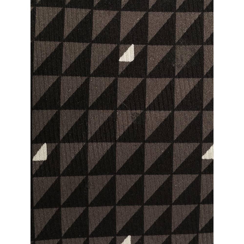 Versace silk tie with geometric pattern in shades of black, gray and white. Model with pointed design.
Years: 2000s

Made in Italy

Width: 7 cm