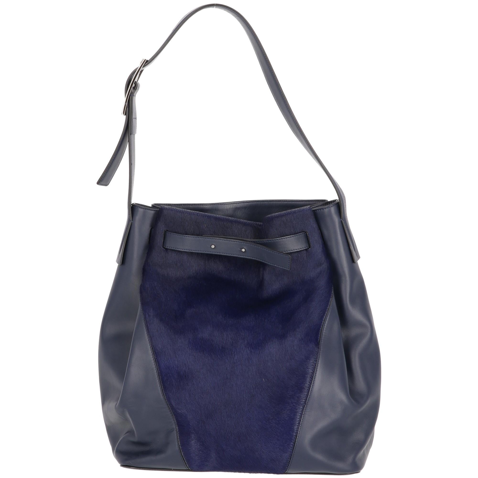 Vince blue leather bag featuring a tone-on-tone calf hair insert on the front. Adjustable shoulder strap, silver-tone metal buckle and leather straps fastening. One inner zip pocket and cotton lining.

Measurements
Width: 27 cm
Height: 31 cm
Depth: