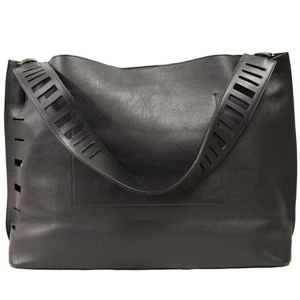 Vince shopper bag in soft black leather with rectangular cut-out details on the shoulder strap and edges. 
Two small internal patch pockets. 
Lined interior in suede. 
Magnetic button closure. 
Excellent condition.

Height: 30 cm
Width: 44 cm
Depth: