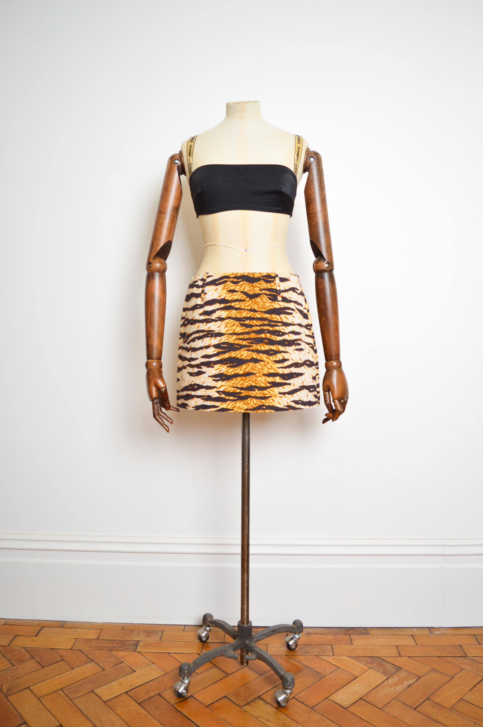 Funky Vintage Y2k, Mid-rise Dolce & Gabbana Mini skirt crafted from a Tiger printed Cotton.  

MADE IN ITALY.  

Zip up side closure closure 
Large Belt Loops 
Archive Print

100% Cotton

Sizing given in inches ; 
Waist/Hip : 28
