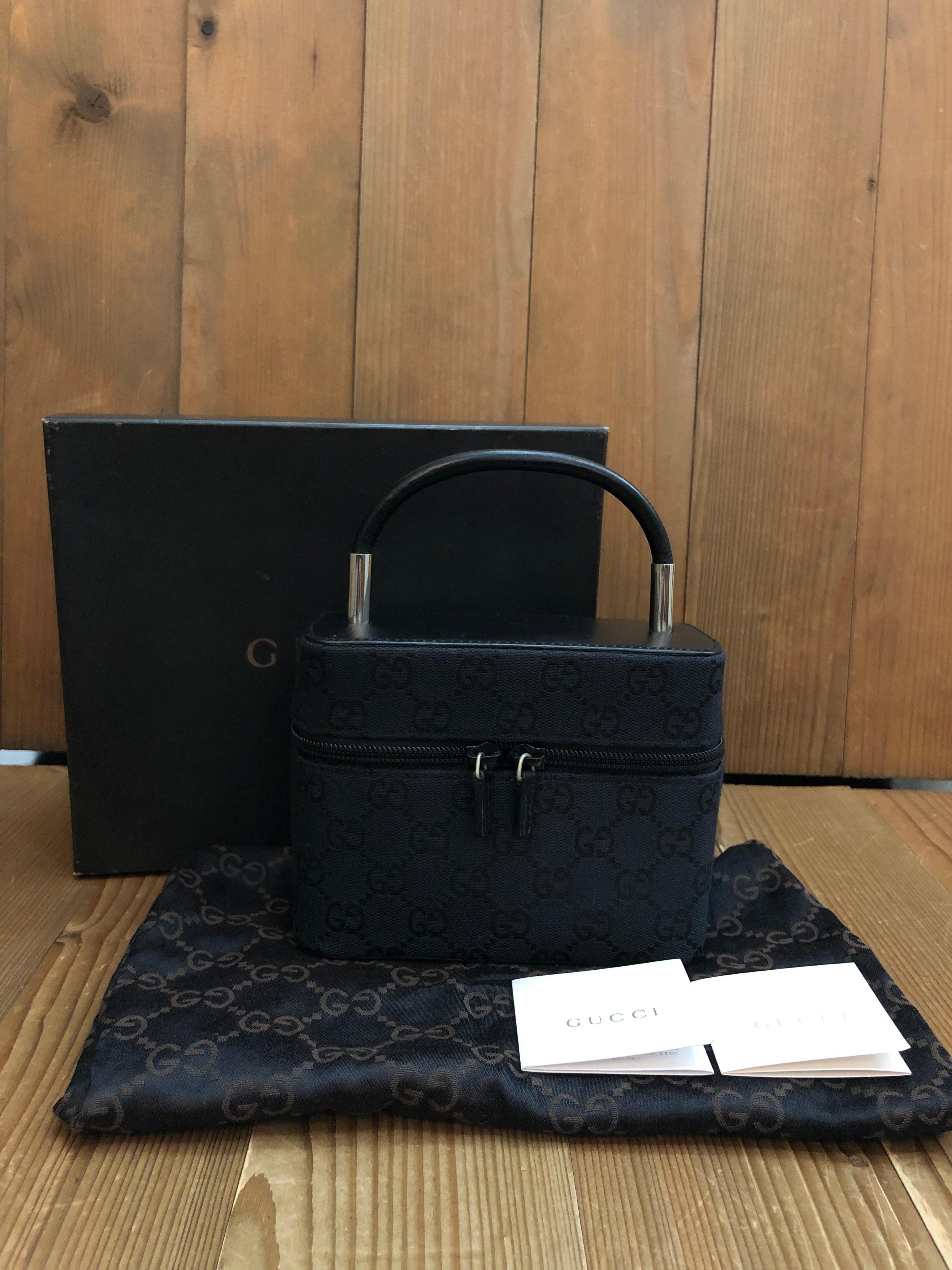 This vintage GUCCI vanity case handbag is crafted of GG jacquard and smooth calfskin leather in black featuring silver toned hardware. Zip-around closure opens to a black GUCCI fabric featuring a zippered pocket and elastic bands. Made in Italy.