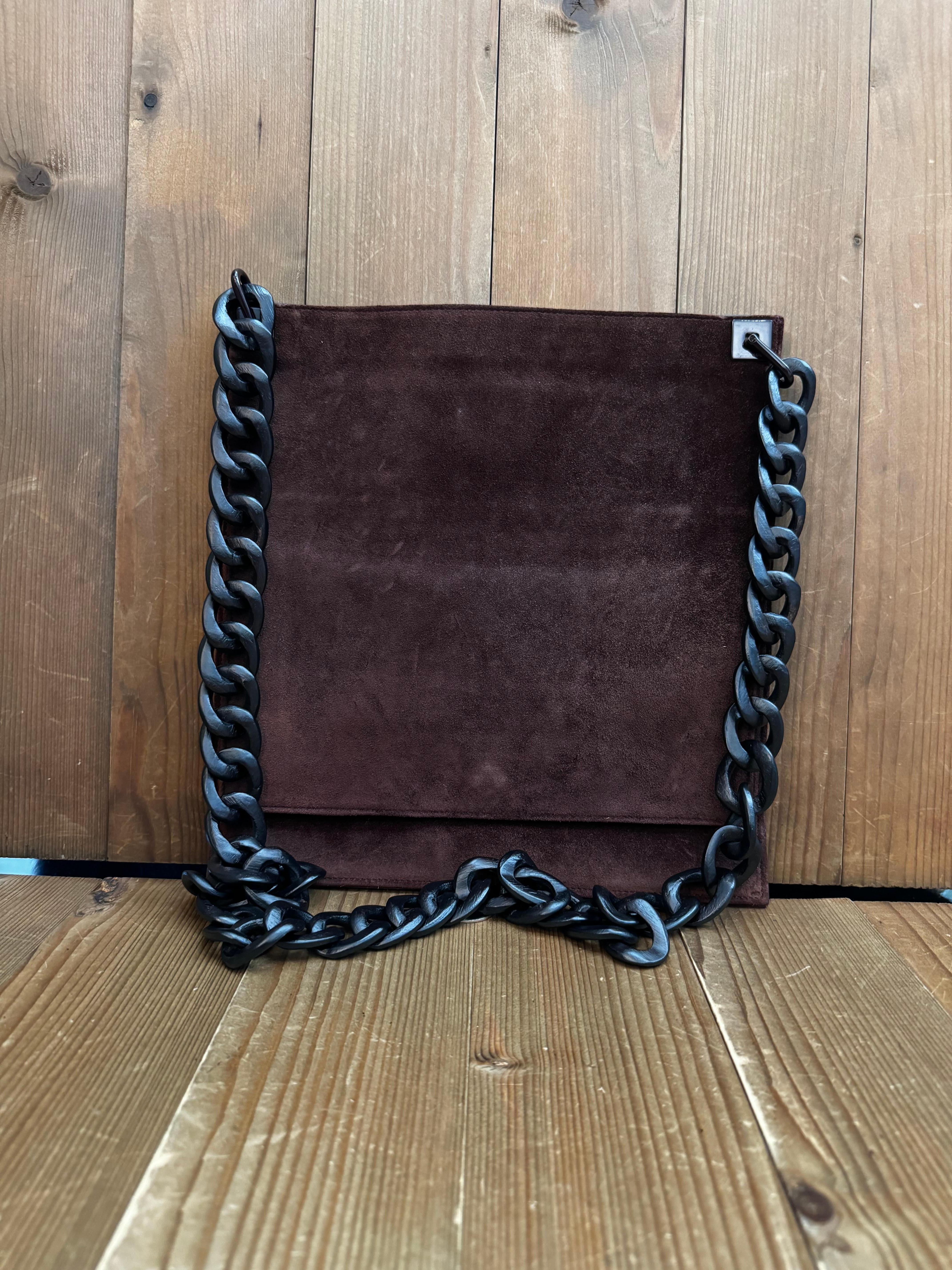 This vintage GUCCI flat messenger bag is crafted of nubuck leather in black featuring a wooden chain. Top opens to the main compartment lined with nubuck leather featuring a patch pocket. The front features a flap pocket with magnetic snap closure.