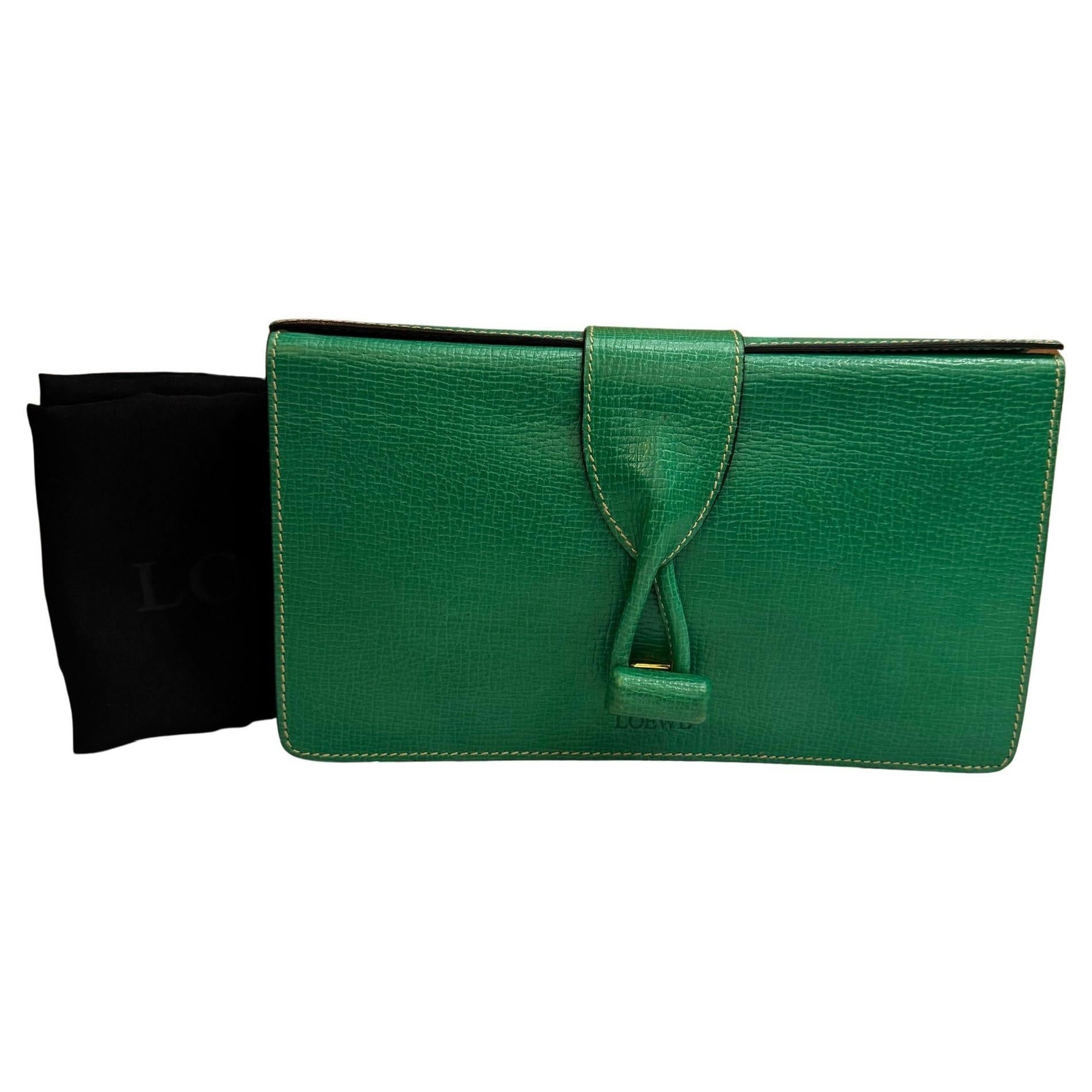 Este bolso caja vintage de LOEWE está fabricado en piel de vacuno repujada de color verde. El cierre frontal giratorio se abre a un interior de piel beige con un bolsillo con cremallera. Fabricado en Italia. Mide aproximadamente 11,5 x 7 x 2