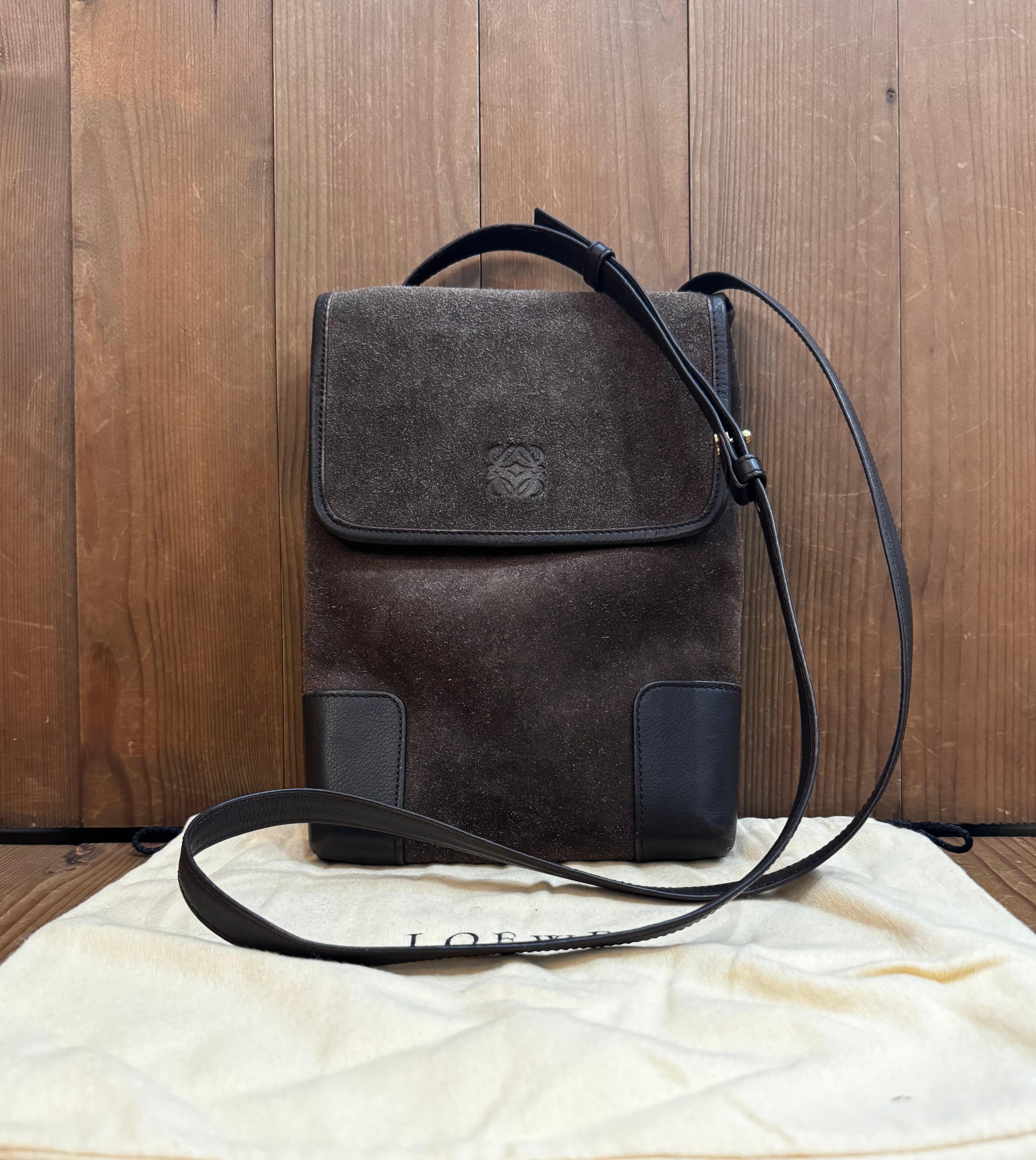 This vintage LOEWE Anagram crossbody bag is crafted of brown calfskin suede and leather featuring a back slip pocket. Front flap magnetic snap closure opens to an unlined interior of smooth calfskin leather. Made in Spain. Measures approximately 9.5