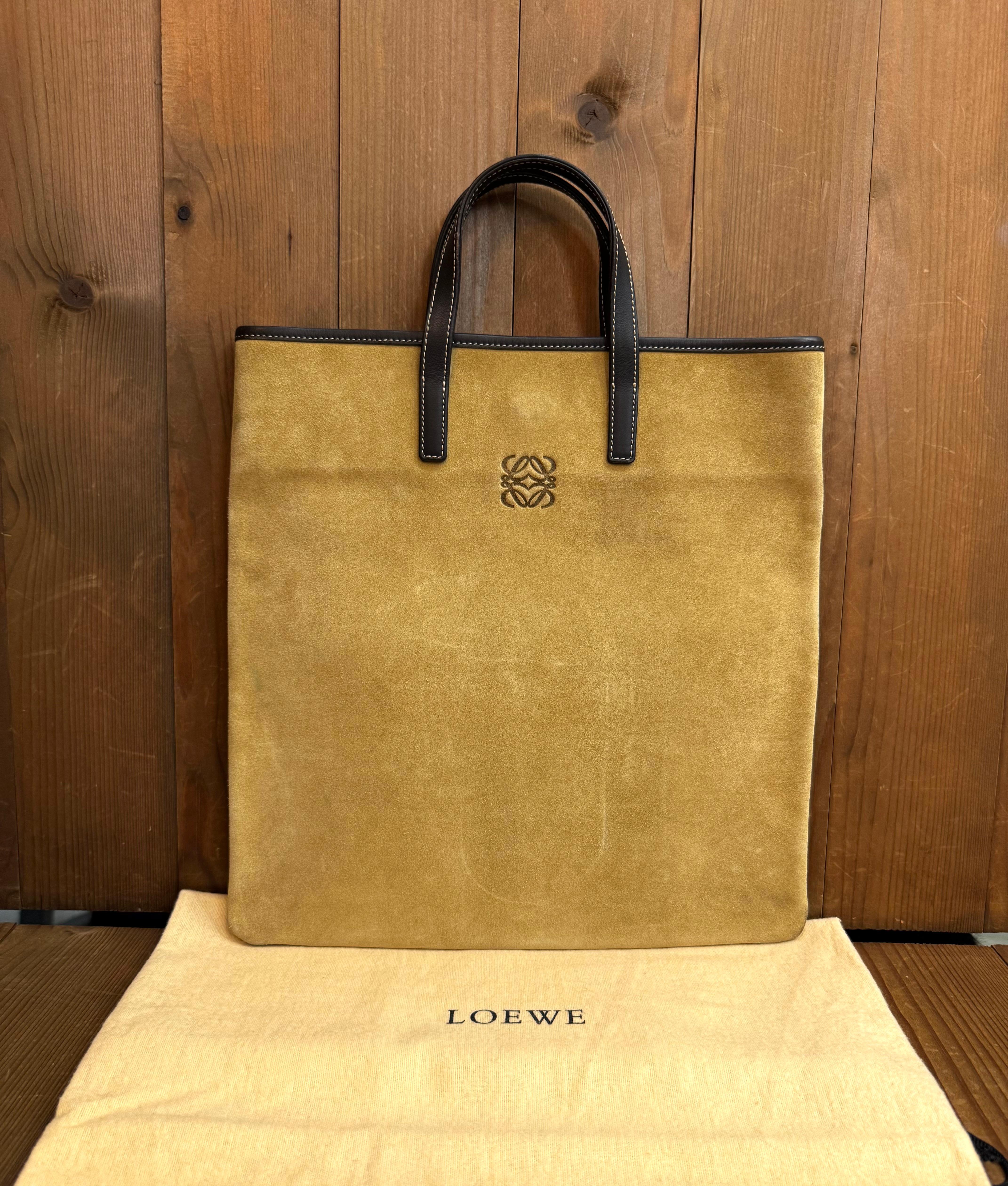 Diese flache LOEWE-Tasche im Vintage-Stil ist aus beigem Kalbsveloursleder gefertigt und mit braunem Kalbsglattleder abgesetzt. Ein magnetischer Schnappverschluss an der Oberseite führt zu einem ungefütterten Kalbsleder-Innenraum, der die andere