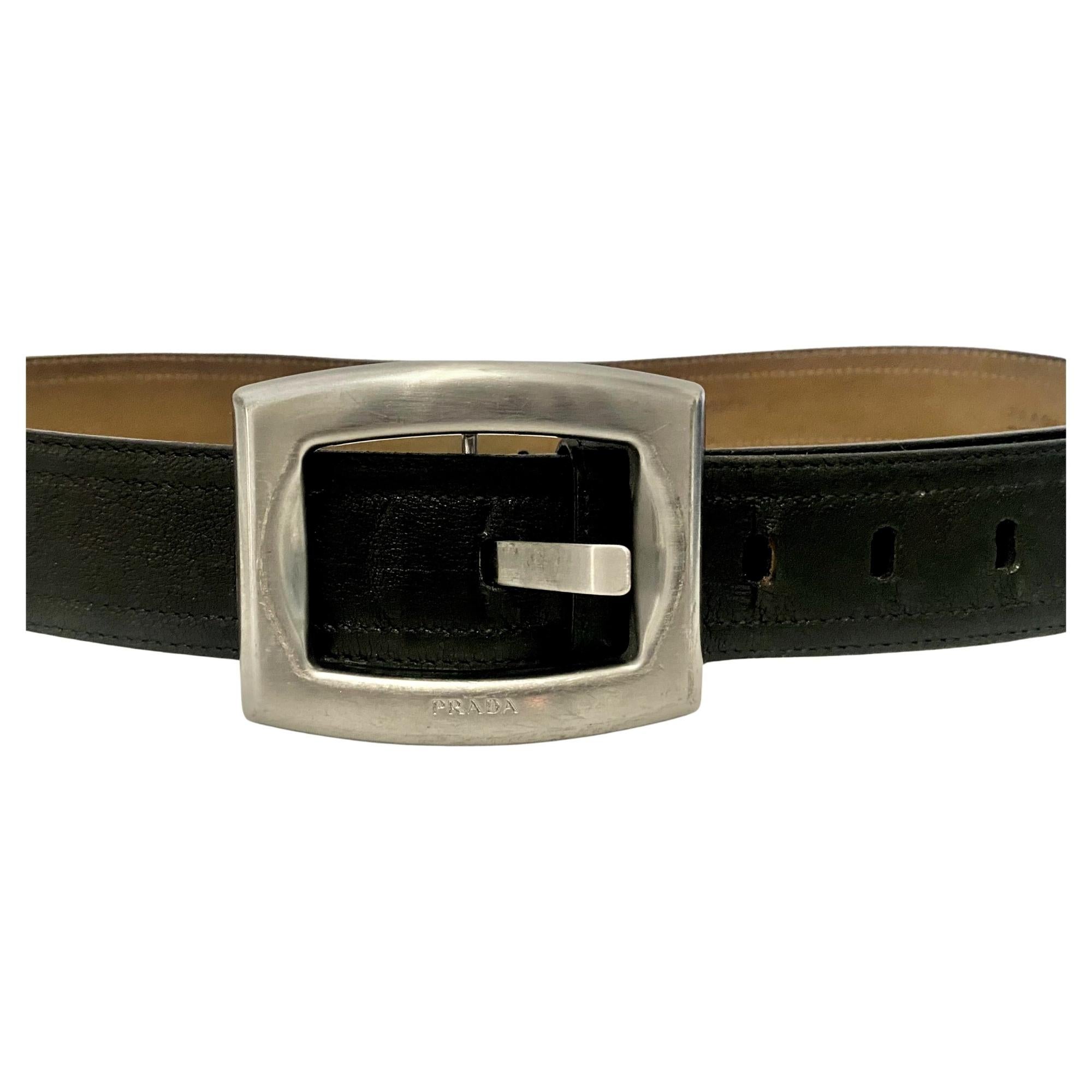 Vintage 2000s Prada Ceinture en cuir noir avec boucle argentée, Made in Italy 
Condit : 200s, vintage., légère usure, bon état général 

Dimensions : 108x4.5cm 
Boucle : 8.5x7cm 