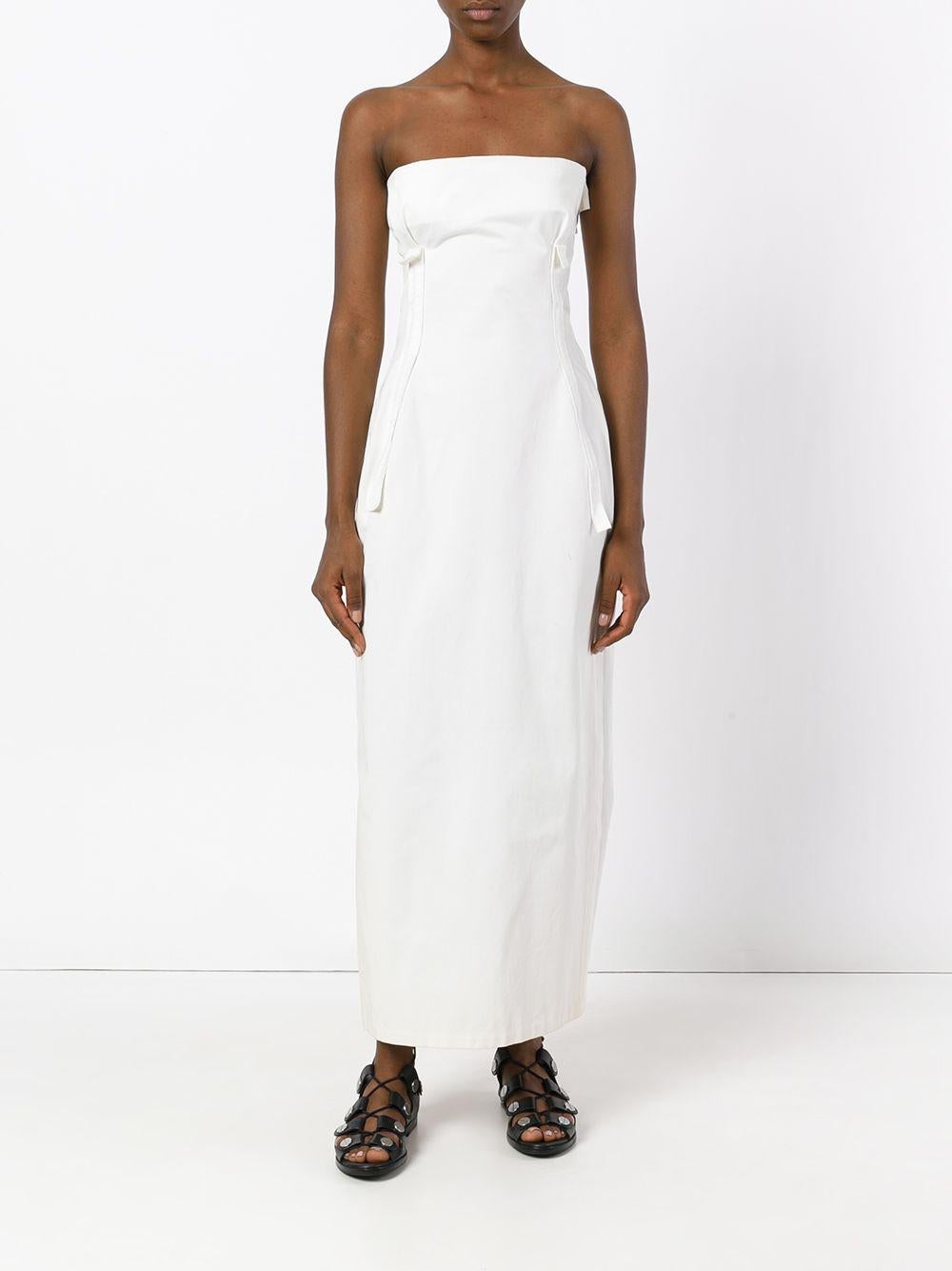 Yohji Yamamoto white cotton long dress, featuring a sleeveless band top, with fabric decorative front applications and crossed seams, silver-tone metal zip and hook side fastening. Pleated detail on the back and fabric application on the
