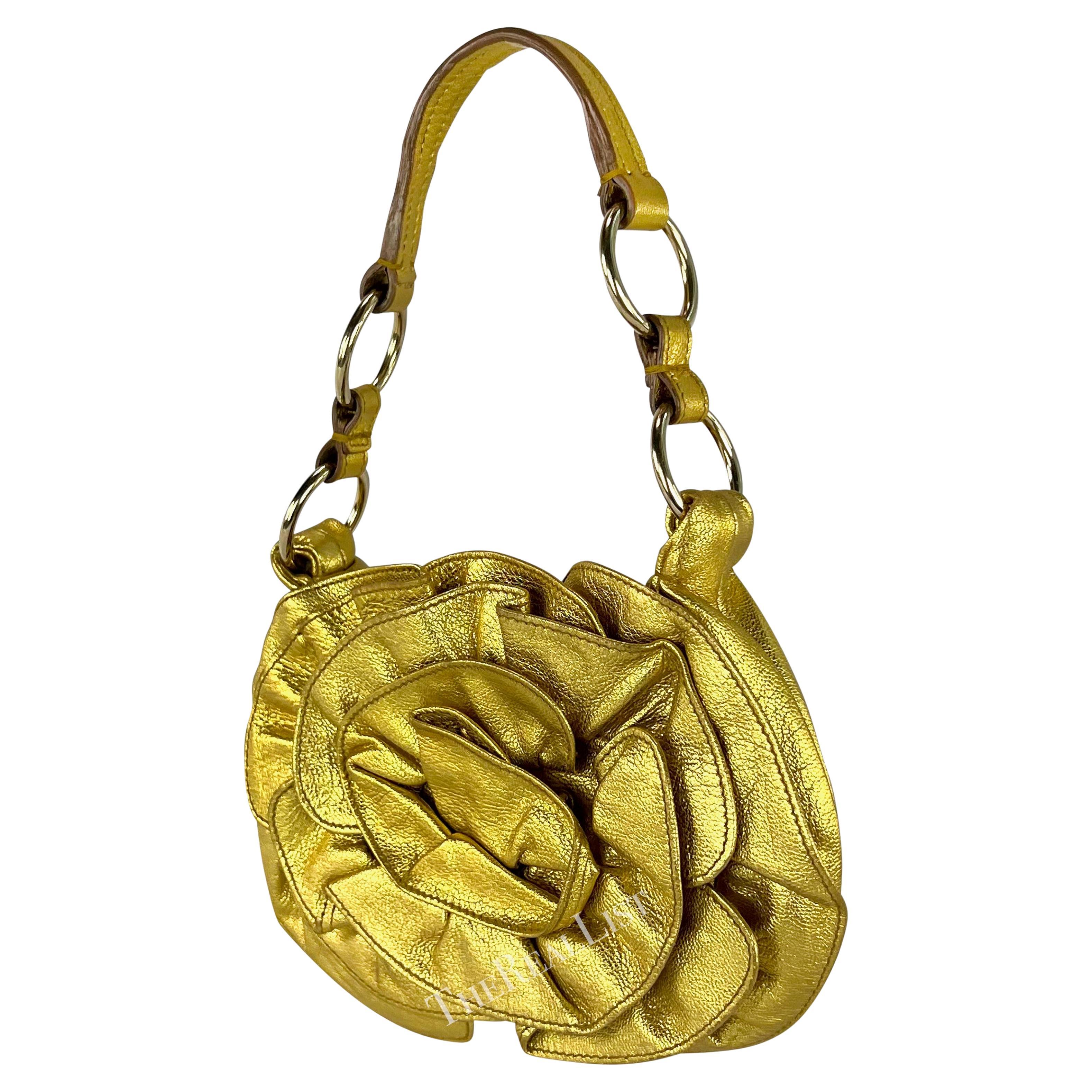 Introducing a stunning gold-tone leather Yves Saint Laurent Rive Gauche mini bag designed by Tom Ford from the early 2000s. Crafted entirely from metallic gold leather, this mini bag showcases an exquisite ruffle floral design, adding an elegant