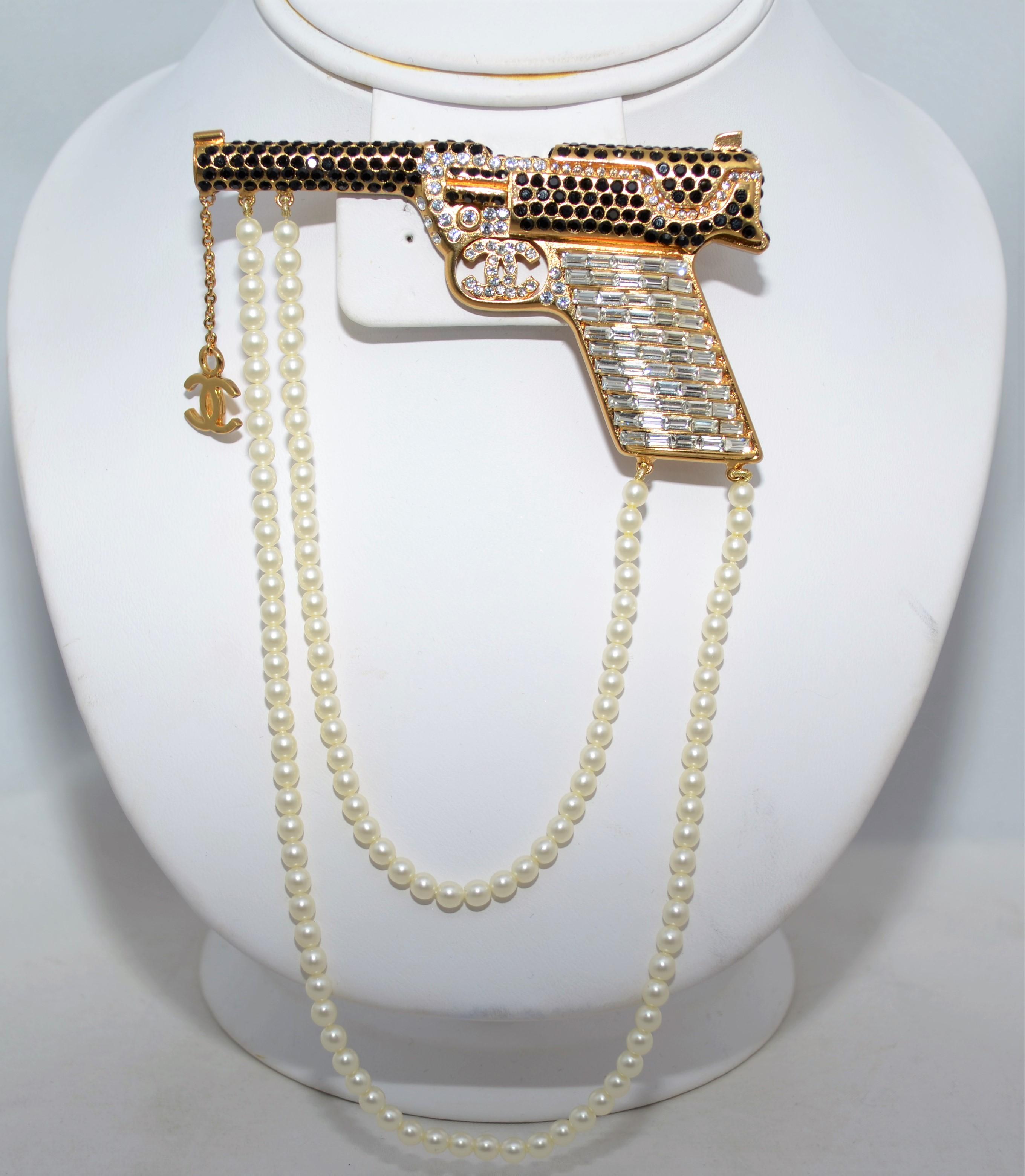 2001 Eine Chanel-Brosche aus goldfarbenem Metall:: durchgehend mit Baguette- und runden Strasssteinen besetzt. Brosche mit zwei Reihen drapierter Perlen. Hergestellt in Frankreich. 

Abmessungen: 
3.5'' lang
Perlen drapieren 6'' lang