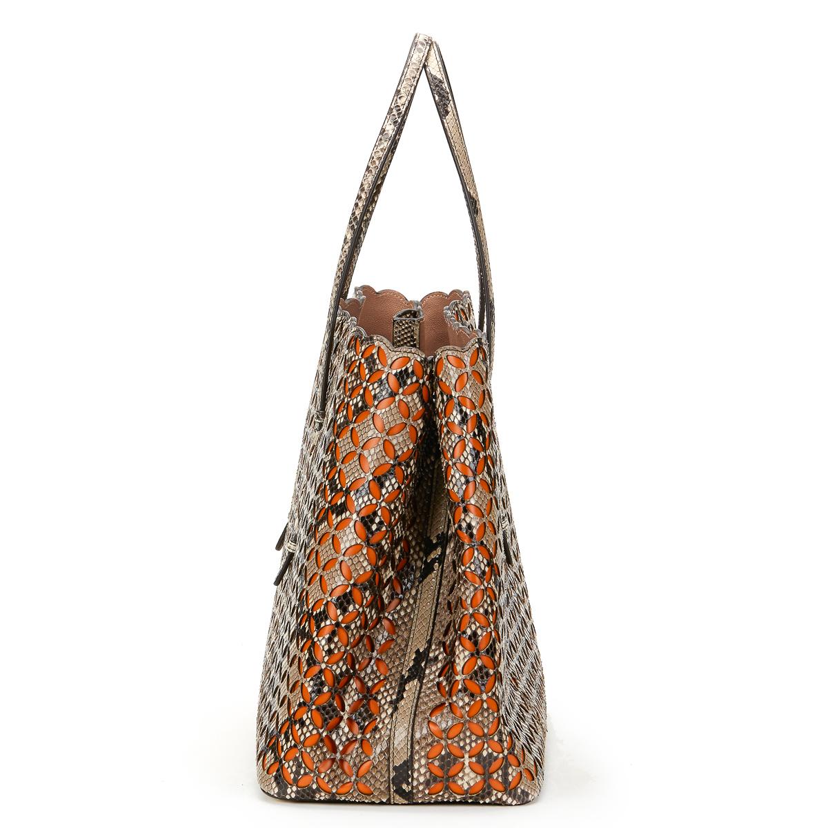 ALAIA
Python Leather & Orange Calfskin Leather Perforated Shopper

Xupes Reference: HB576
Age (Circa): 2001
Accompanied By: Mirror, Interior Pouch
Authenticity Details: (Made in Italy)
Gender: Ladies
Type: Shoulder, Tote, Shopper

Colour: