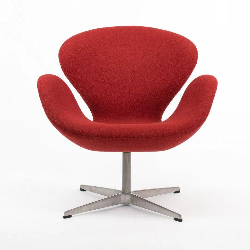 Il s'agit d'une chaise Swan, modèle 3320, conçue par Arne Jacobsen pour Fritz Hansen en 1958. Ce modèle est doté d'une base en aluminium à 4 branches et est revêtu d'un tissu bouclé en laine rouge. Le prix indiqué comprend une chaise Swan, et nous