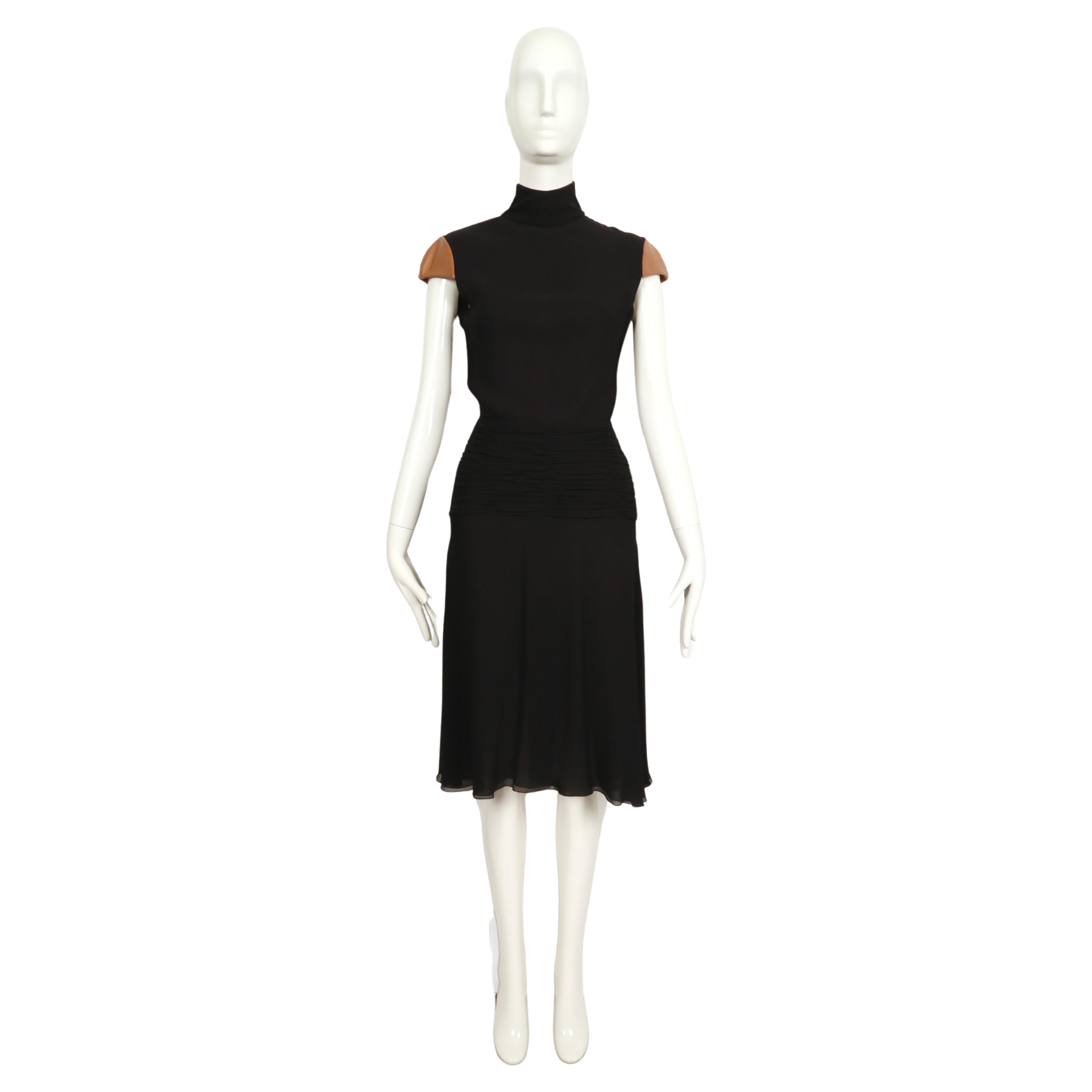 Black silk chiffon dress with ruched hip, open back and leather cap sleeves designed by Gianni Versace for the Gianni Versace Couture label dating to fall of 2001 exactly as seen on the runway. Italian size 40. Approximate measurements: bust 33